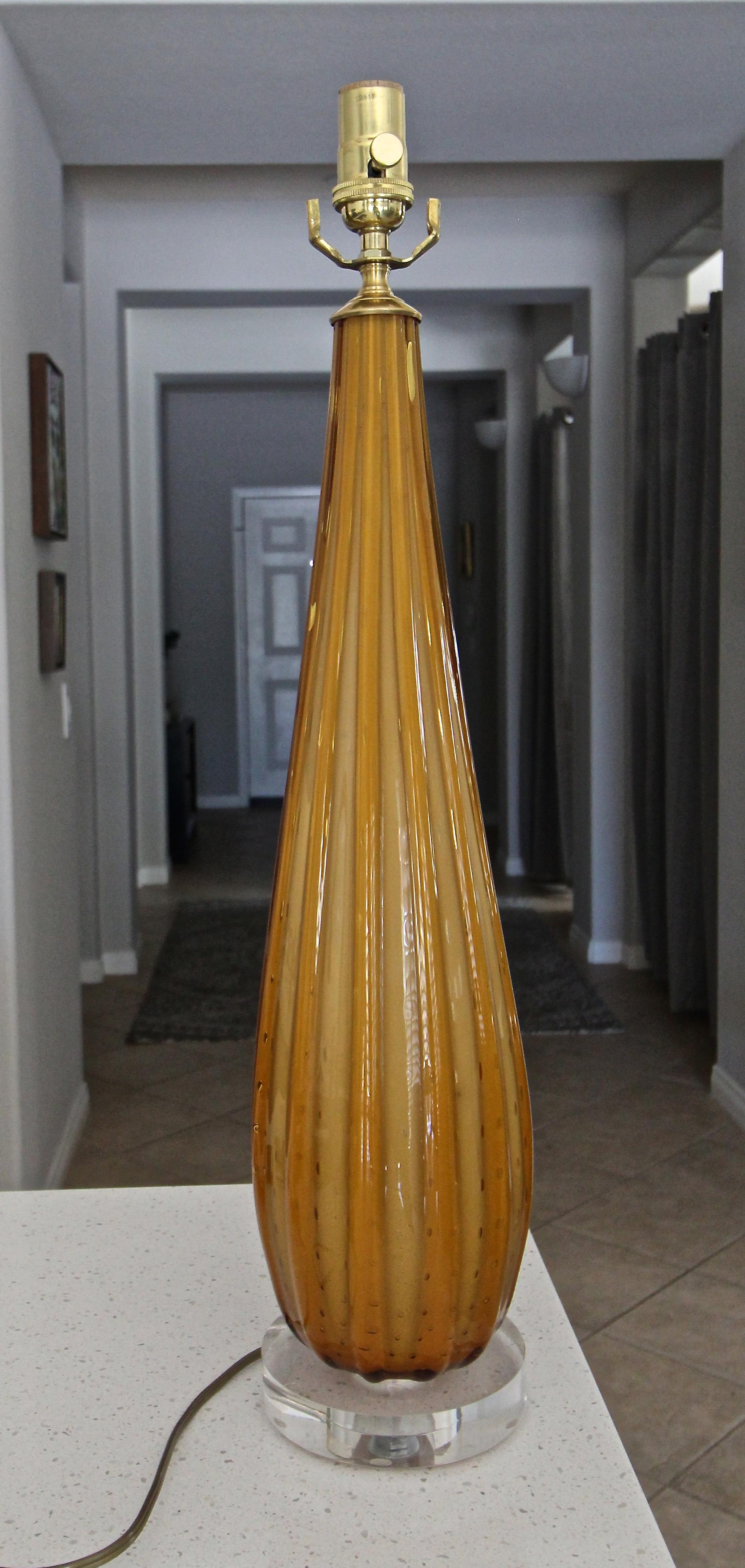 Lampe de table en verre de Murano strié de couleur orange avec des bulles contrôlées. Le verre strié donne à la lampe des nuances alternées d'orange. Nouvellement câblé pour les États-Unis sur une base acrylique personnalisée avec des raccords en