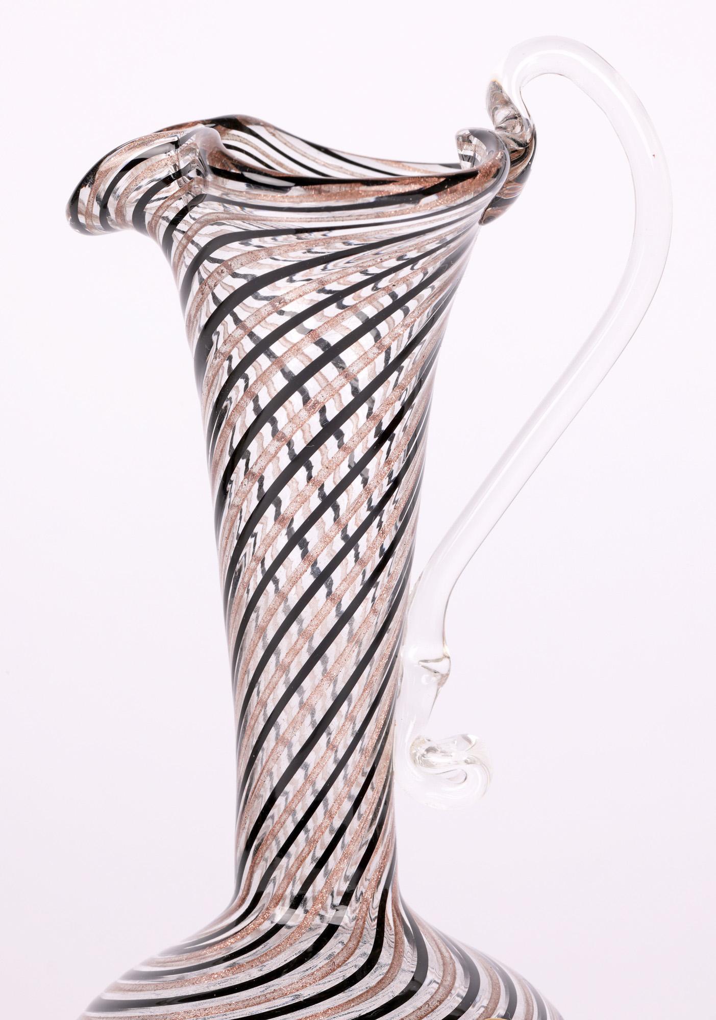 Une très belle cruche en verre soufflé à la main de Murano, à motif de ruban, datant de la fin du 20e siècle. La cruche au corps arrondi en forme d'oignon est marquée d'un pontil rugueux en creux, avec un haut col en forme de trompette et un large