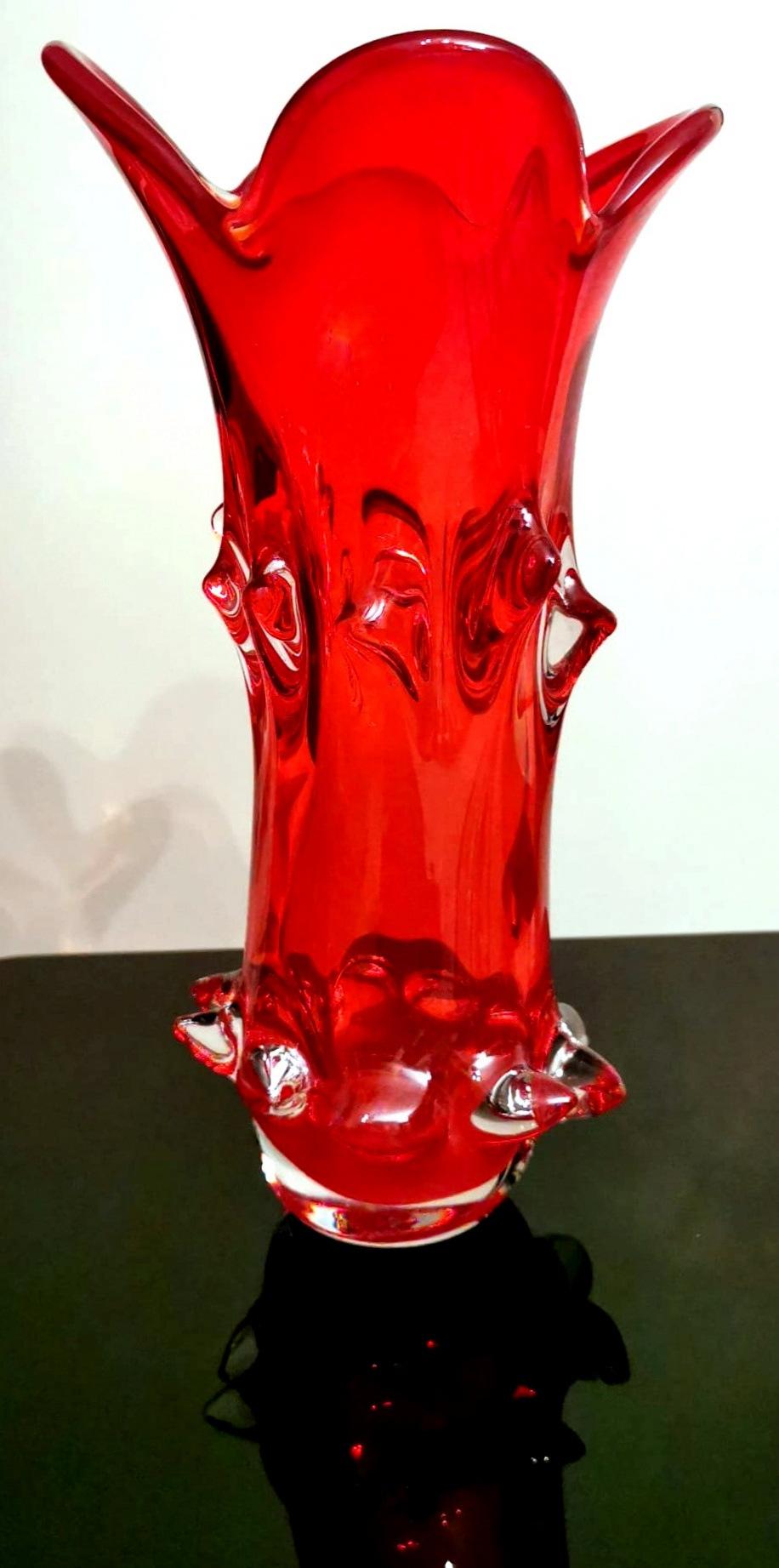 Nous vous suggérons de lire la description complète, car nous essayons de vous donner des informations techniques et historiques détaillées pour garantir l'authenticité de nos objets.
Séduisant vase rouge en verre de Murano (Italie) soufflé selon