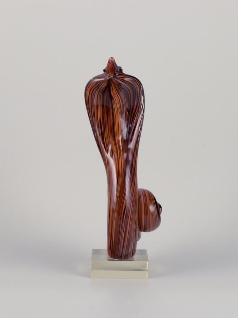 Murano, Italien. Große Skulptur, die eine Kobra-Schlange darstellt und aus Kunstglas gefertigt ist. 
Das Glas ist in Braun- und Orangetönen gehalten und hat einen klaren Glasboden.
Ungefähr in den 1970er Jahren.
In perfektem Zustand.
Abmessungen: B