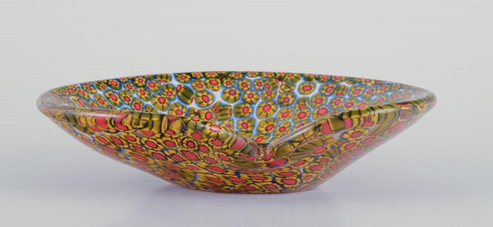 Murano, Italy. A millefiori art glass bowl.
From the 1970s.
Red, yellow, and blue tones.
In perfect condition.
Dimensions: L 15.8 cm x W 11.5 cm x H 3.2 cm.
The term millefiori is a combination of the Italian words 