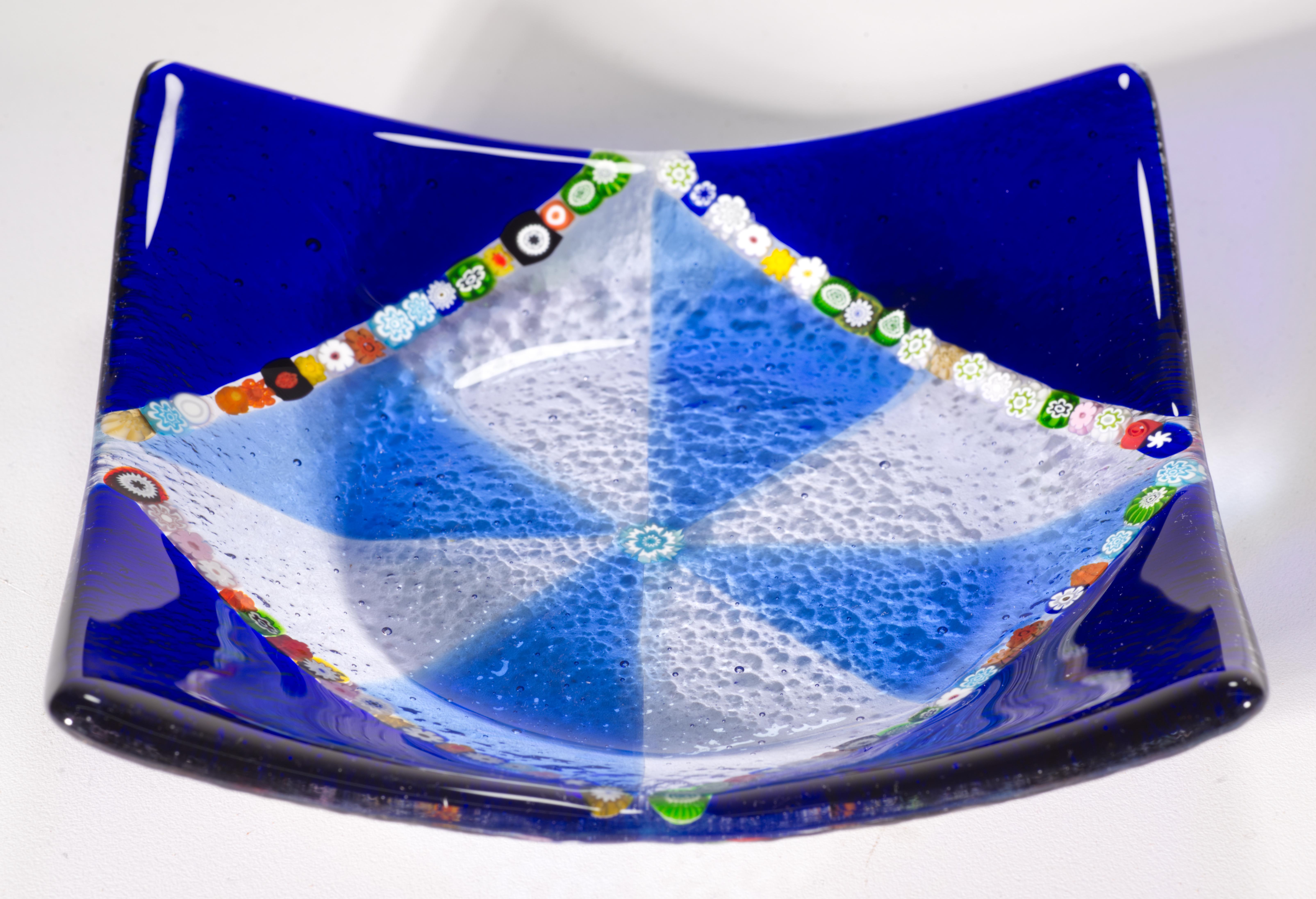  Plateau ou bol vintage en verre soufflé à la main de Murano présentant 4 rangées d'éléments millefiori multicolores différents, disposés en forme de carré au centre du plateau. Les coins extérieurs du plateau sont en verre bleu cobalt foncé, et le