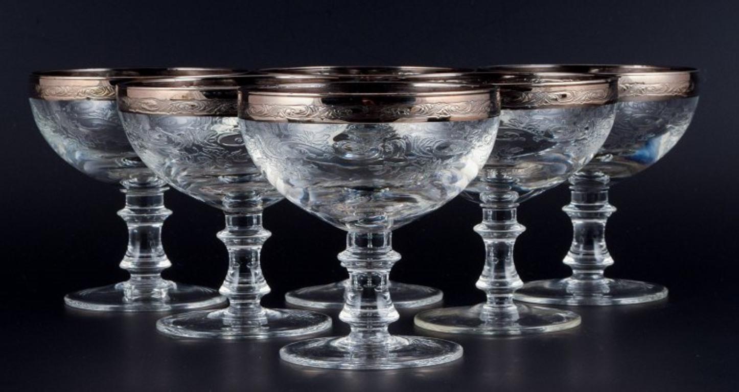 Murano, Italy, six mouth-blown engraved champagne glasses with silver rim.
Mid-20th century.
In perfect condition.
Dimensions: H 12.2 x 10.0 cm.




