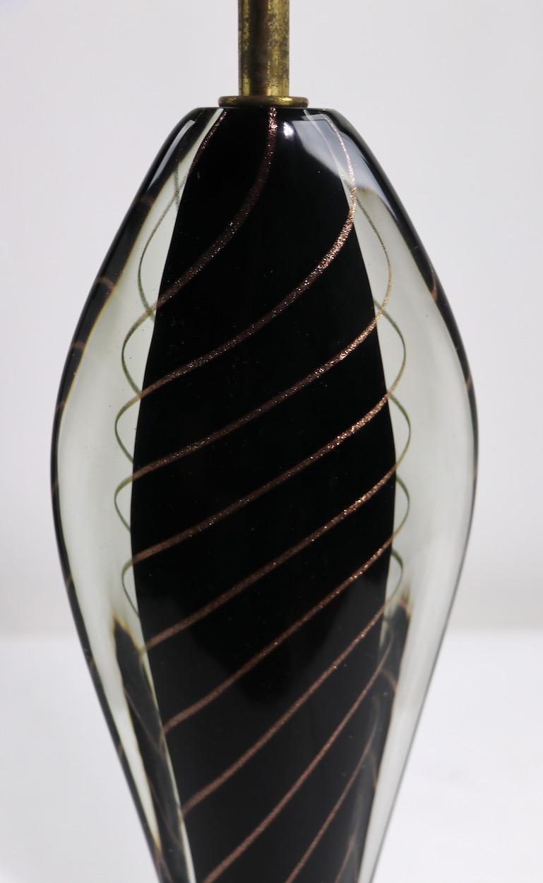 Elegante lámpara de mesa de Murano de Flavio Poli para Seguso, importada por Camer Venice New York. Llamativo interior negro con contorno de hilo dorado arremolinado, sobre base de madera pintada de imitación. Este ejemplar está en excelentes