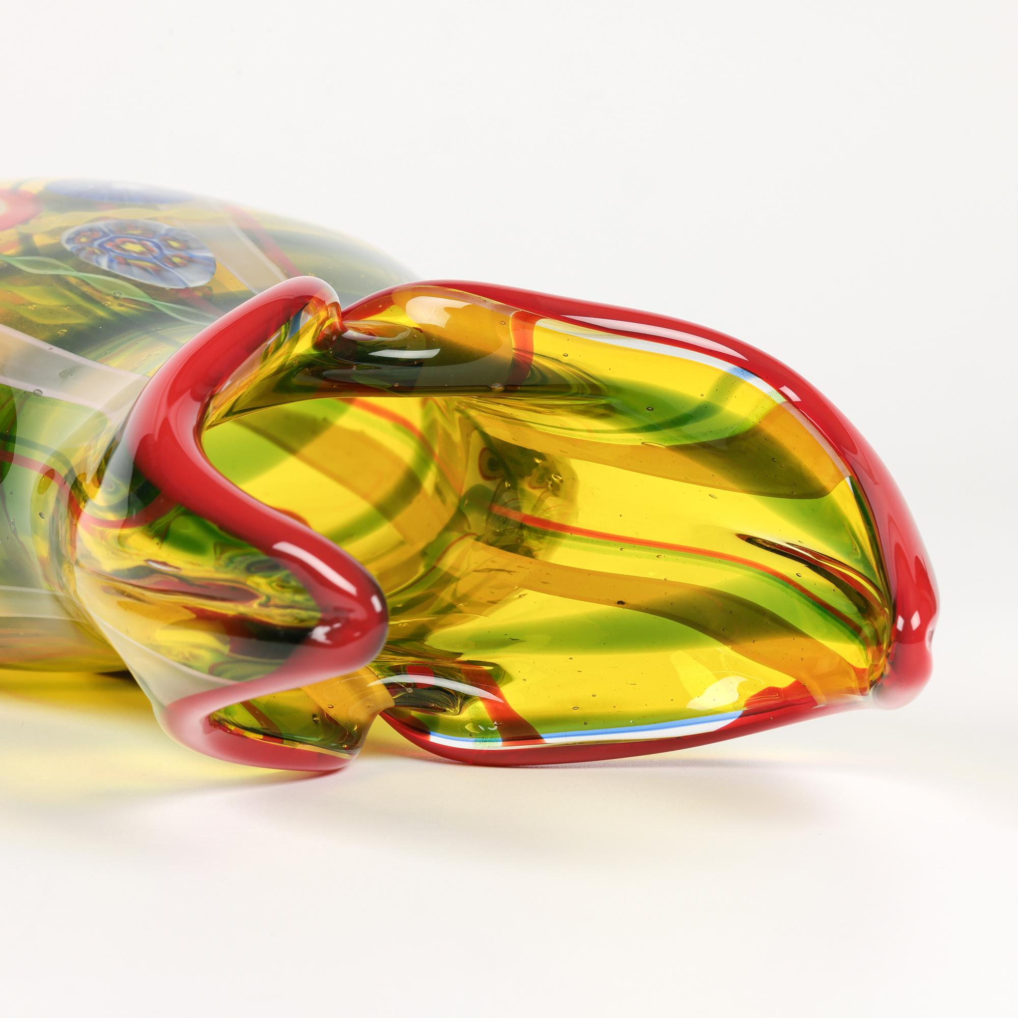 Superbe vase en verre d'art italien de Murano du milieu du siècle, à deux cornes, de couleur jaune, avec des motifs de murrine et de ruban.  
Le vase en verre soufflé à la main est de facture robuste, reposant sur une étroite base ovale polie et