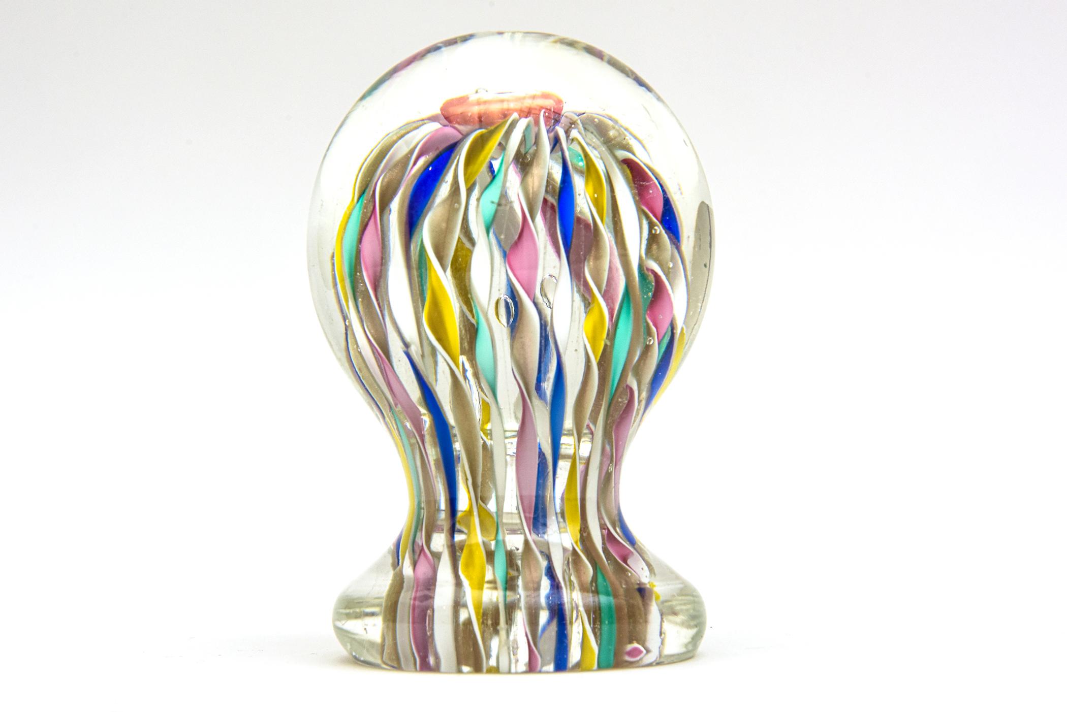 This colorful Italian Murano hand blown glass paperweight sculpture has a dome mushroom top with internal cascading colorful ribbons of glass called Latticino. The colors are rich and range from royal blue, pink, mint green, mustard yellow, white