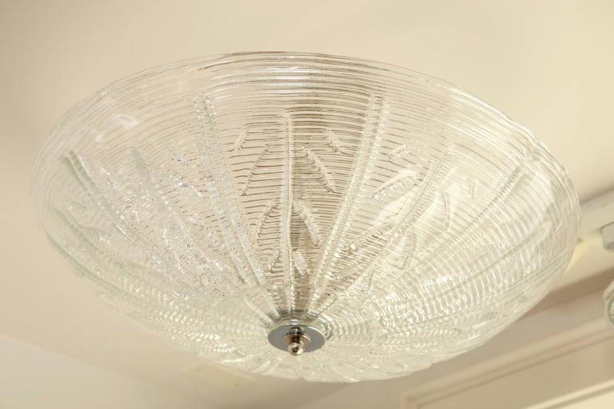 Striking Murano blown  dome shaped ceiling fixture shown with a ribbed and a stylized leaf pattern.
Note while this glass is blown clear the textures and thickness of the glass diffuse bulb spotting.
Made install ready and electrified to code for US