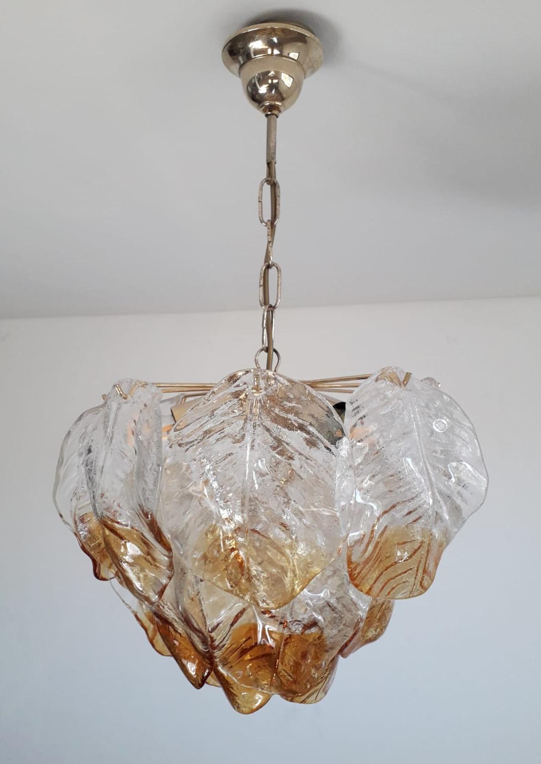 Vintage Italian chandelier with clear and amber hand blown textured Murano glass leaves suspended on brass frame / Made in Italy by Mazzega, circa 1960s
Measures: diameter 16 inches, chandelier height 14 inches, total height 26 inches including