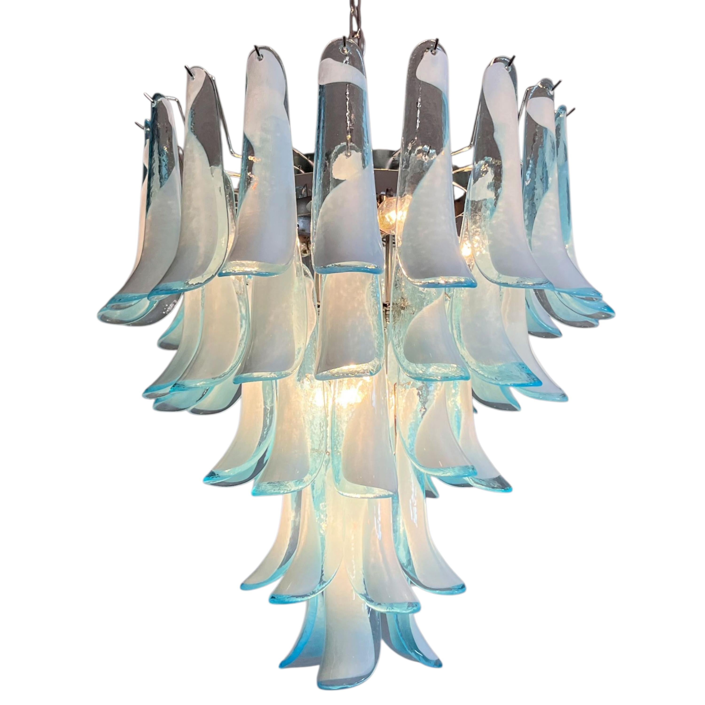 Eine elegante Sinfonie aus Glas und Licht, die zwischen Tradition und modernem Design schwebt.
Dieser außergewöhnliche Kronleuchter aus hellblauem Opalglas aus Murano, der 2025 in Handarbeit hergestellt wurde, ist eine der schönsten zeitgenössischen
