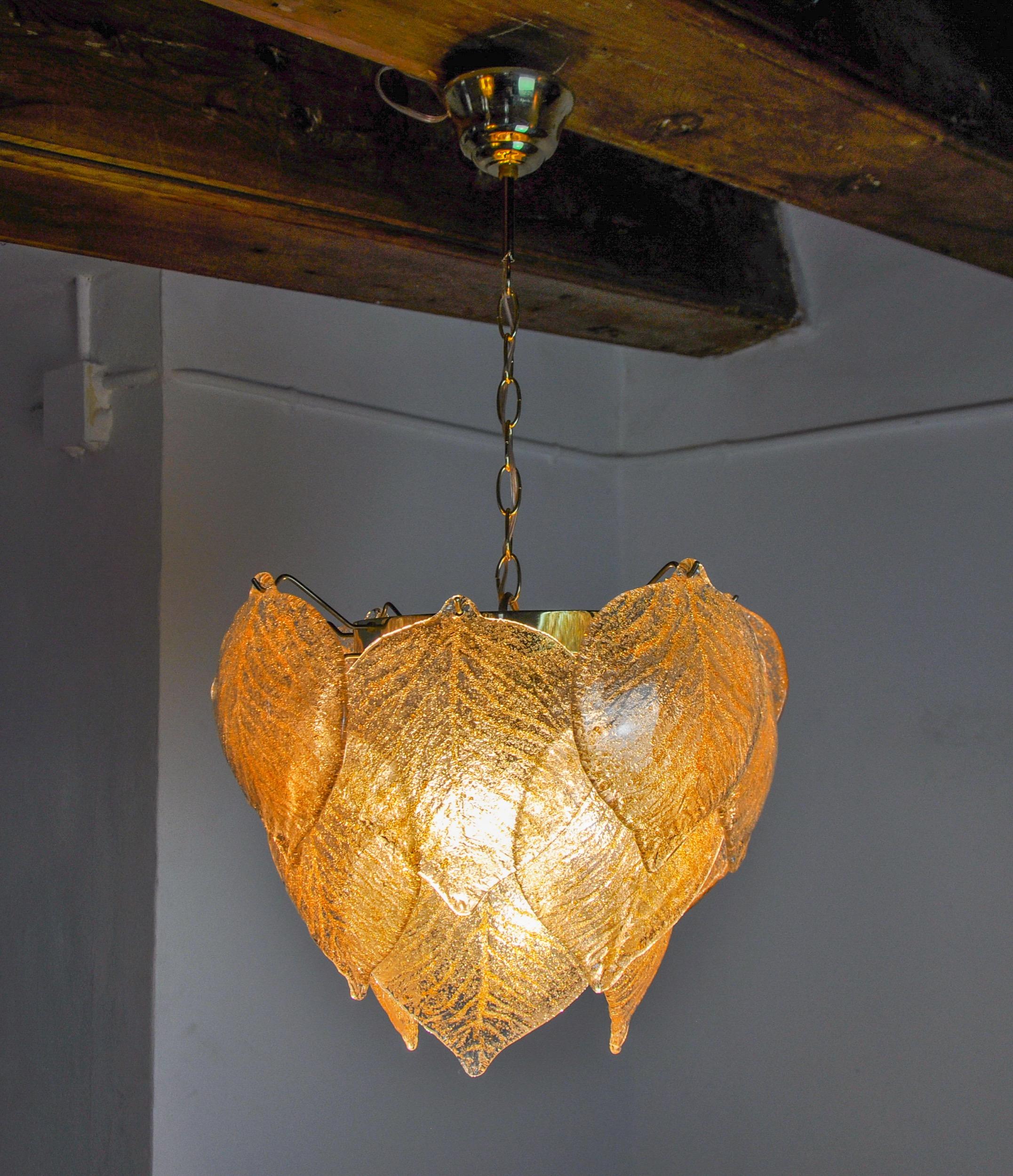 Superbe et rare lustre Murano Mazzega produit en Italie dans les années 70. Cristaux en verre de Murano dépoli, en forme de feuilles réparties sur une structure en métal doré. Objet unique qui illuminera à merveille et apportera une véritable touche