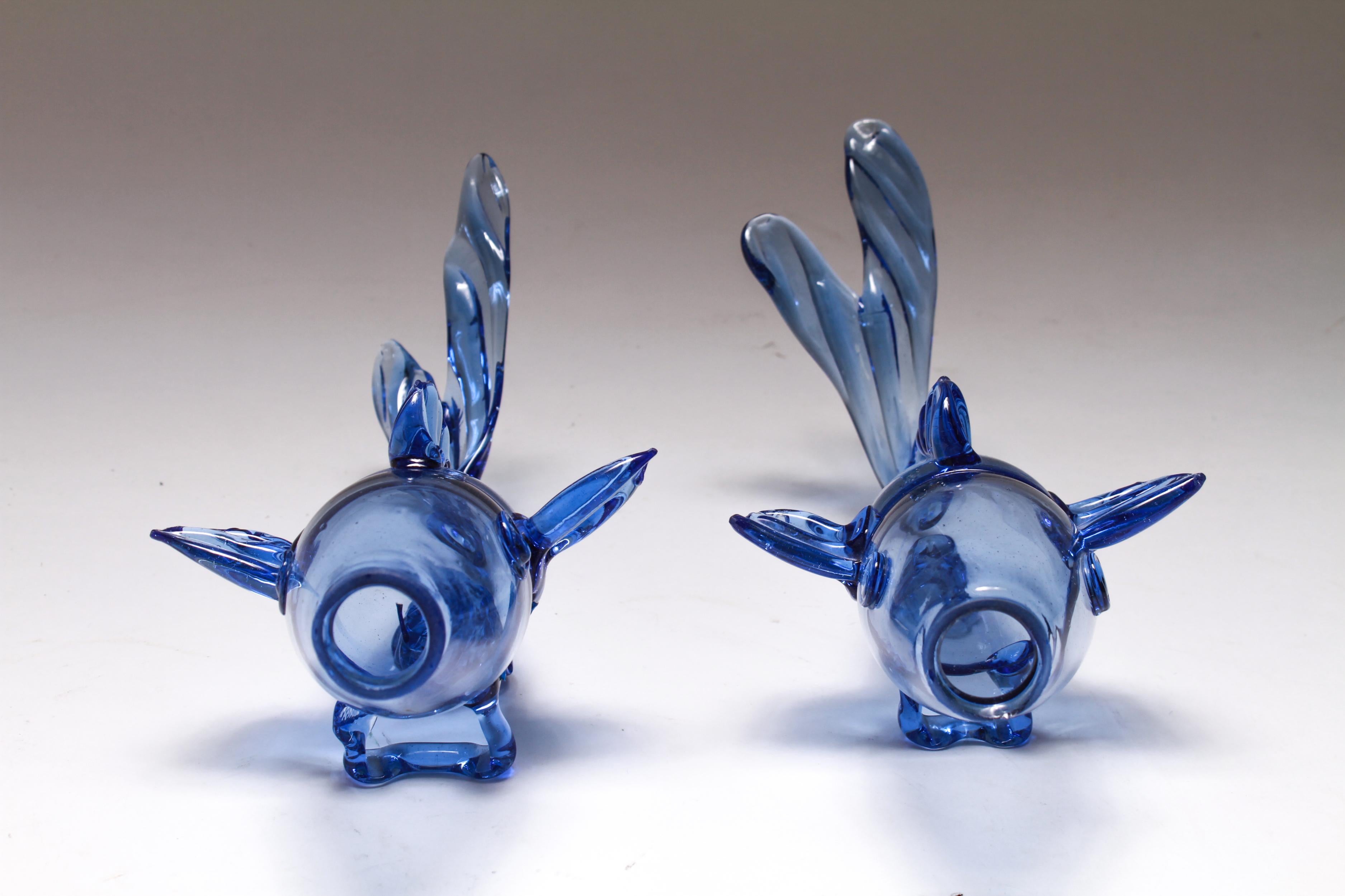 Pair of Murano Venetian hand blown blue glass fish figurines with applied fins, tails, eyes, and braces. The pair is in great vintage condition with a few tiny fleabite chips to fin edges and mouths.