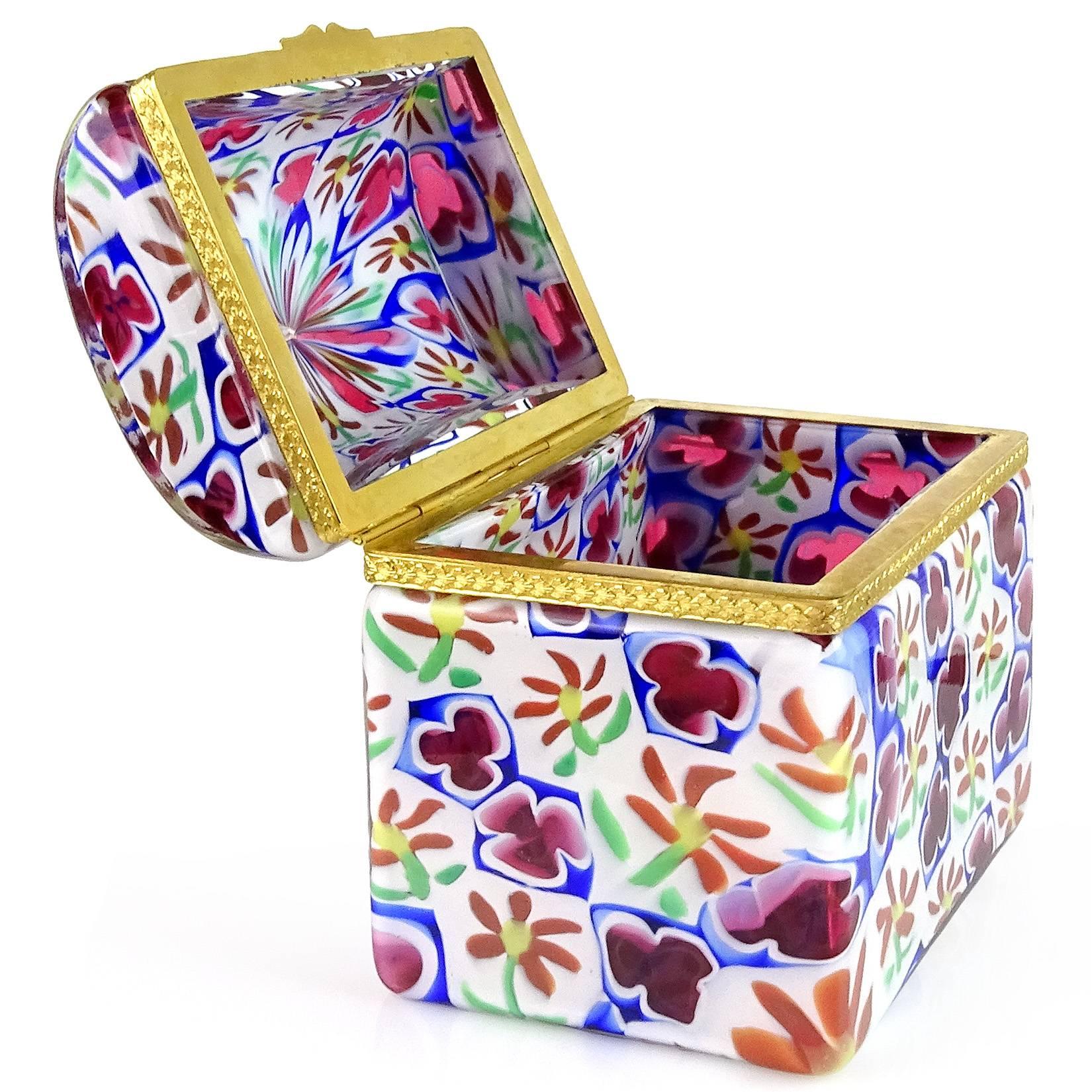 Gorgeous Murano hand blown Millefiori daisy and clover Italian art glass casket jewelry box. Documented to the Fratelli Toso company. It has a treasure chest / trunk shape. The mosaic design has white, orange, green, purple / pink and cobalt blue