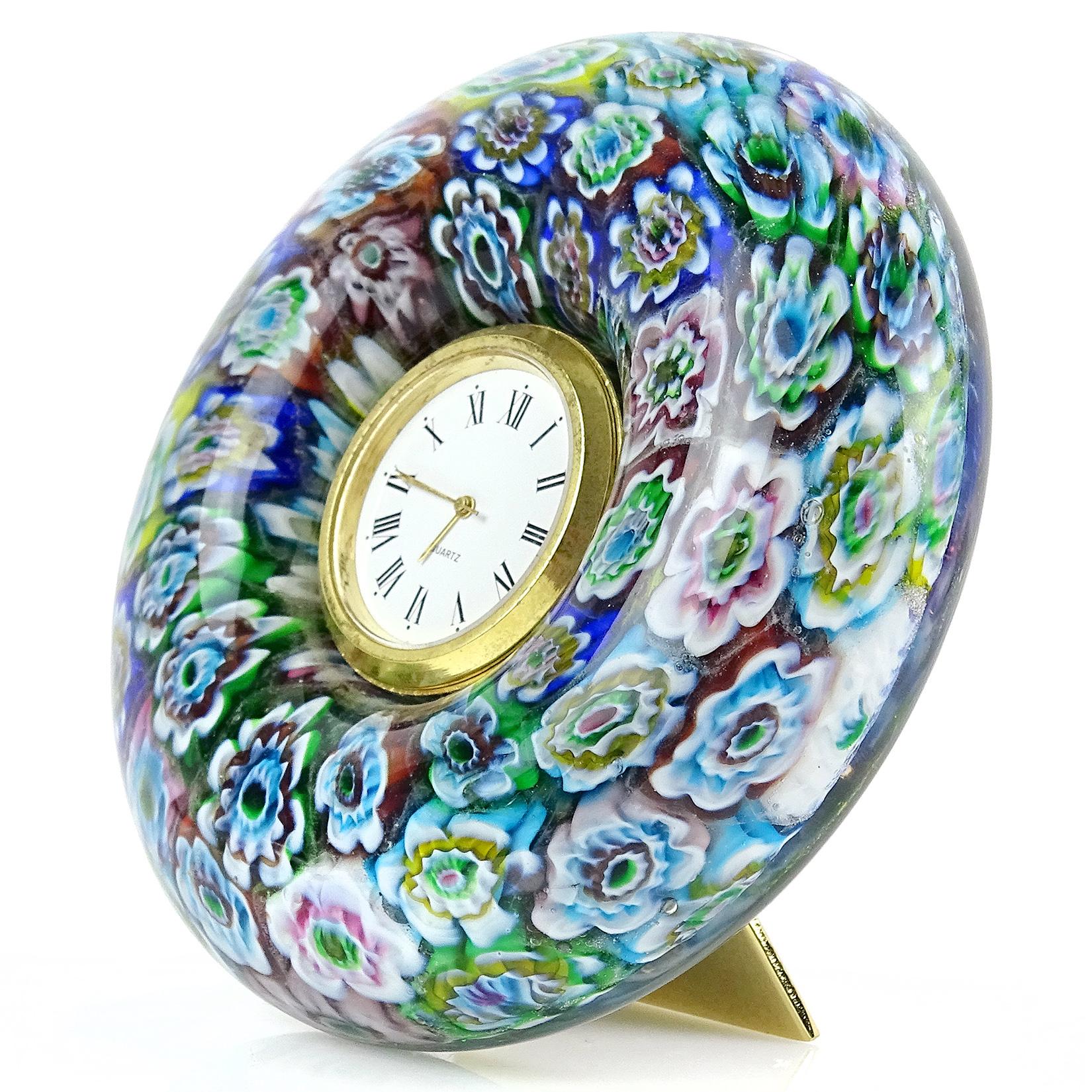Beautiful Murano hand blown millefiori flower mosaic Italian art glass desk clock. It has a Quartz clock face, a triangle stand on the back, and battery operated clock face (new battery needed). Has original 