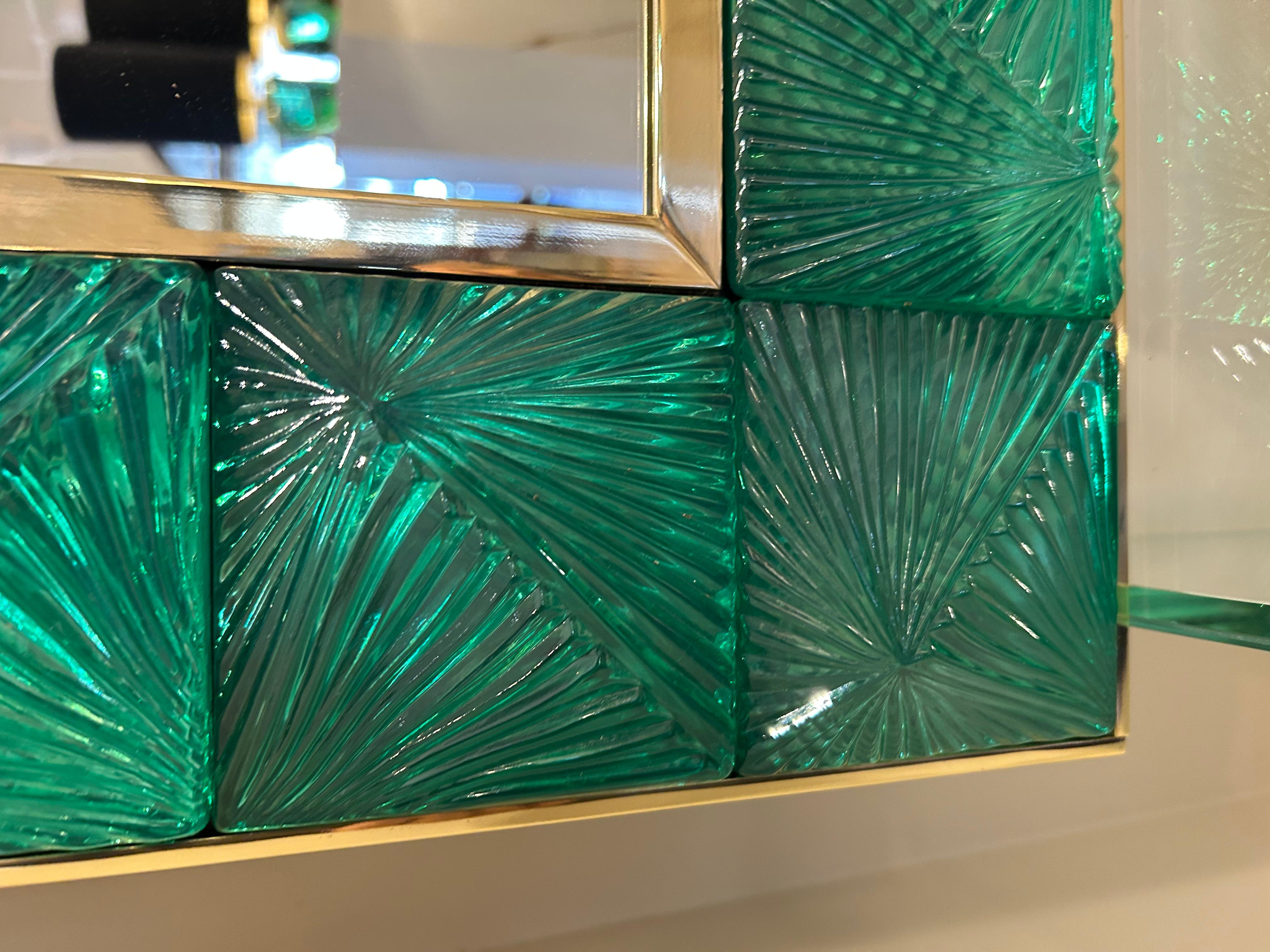 Miroir en verre ciselé de Murano, vert émeraude. Structure en laiton doré. Ce miroir peut très bien être fixé à l'horizontale ou à la verticale. Fixation au dos prévue.
Peut être placé sur une console, une commode.
