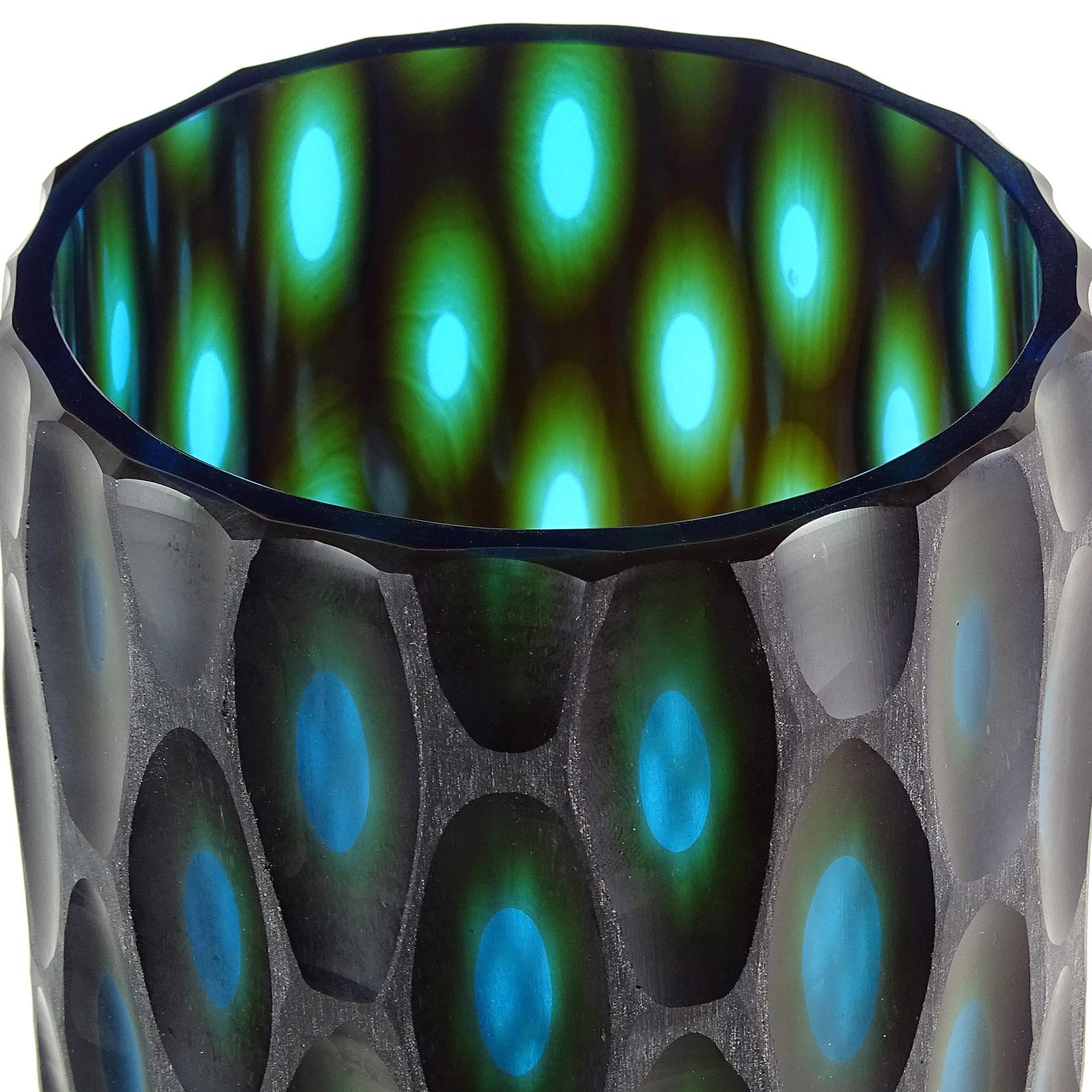 Large modern Murano hand blown black over blue green layers Italian art glass sculptural flower vase with carved surface. The piece has carved ovals throughout, showing the blue and green layers. Measures: 13 1/4