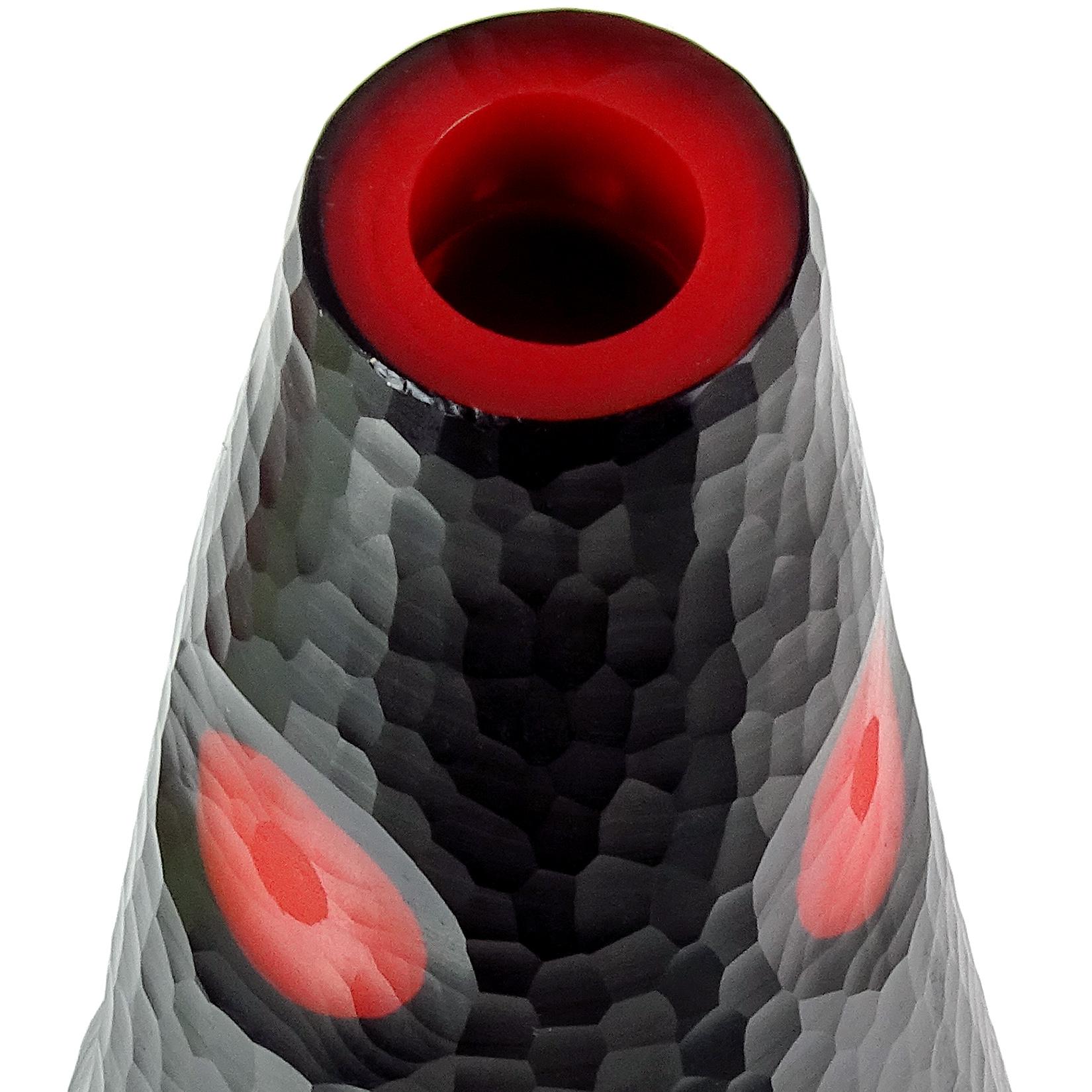 Beautiful Murano hand blown black over red core Italian art glass sculptural flower vase with carved surface. Created in the manner of the Venini company. The piece has carved circles, showing the red inside layer. Measures: 11 1/4