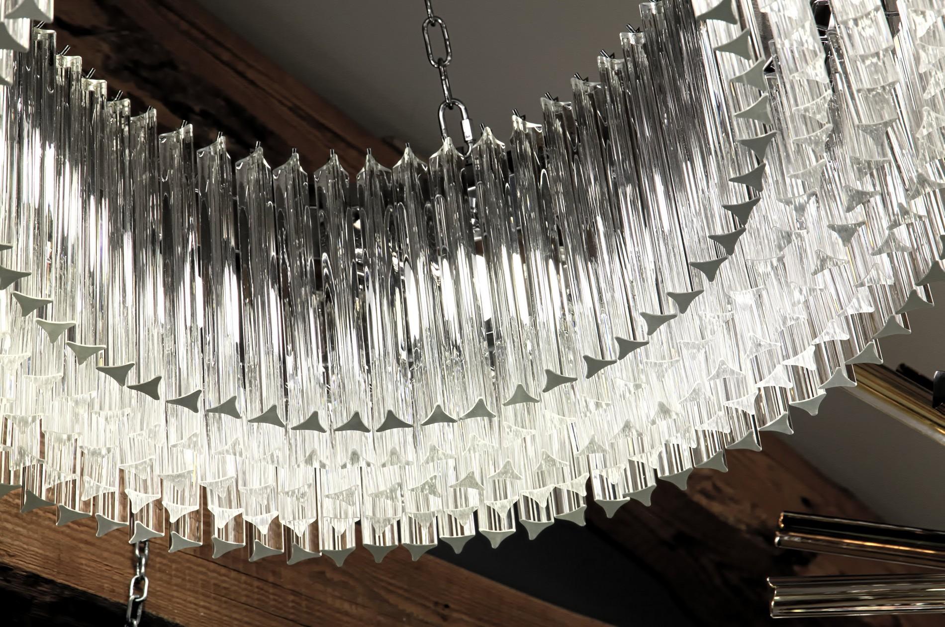 A modern version of a Classic chandelier using a ring of 5 layers of Triedri. Creates a great architectural effect and use of space.
There are more than 350 elements of two lengths. The two fencing layers are 30 cm tall and the middle ones are