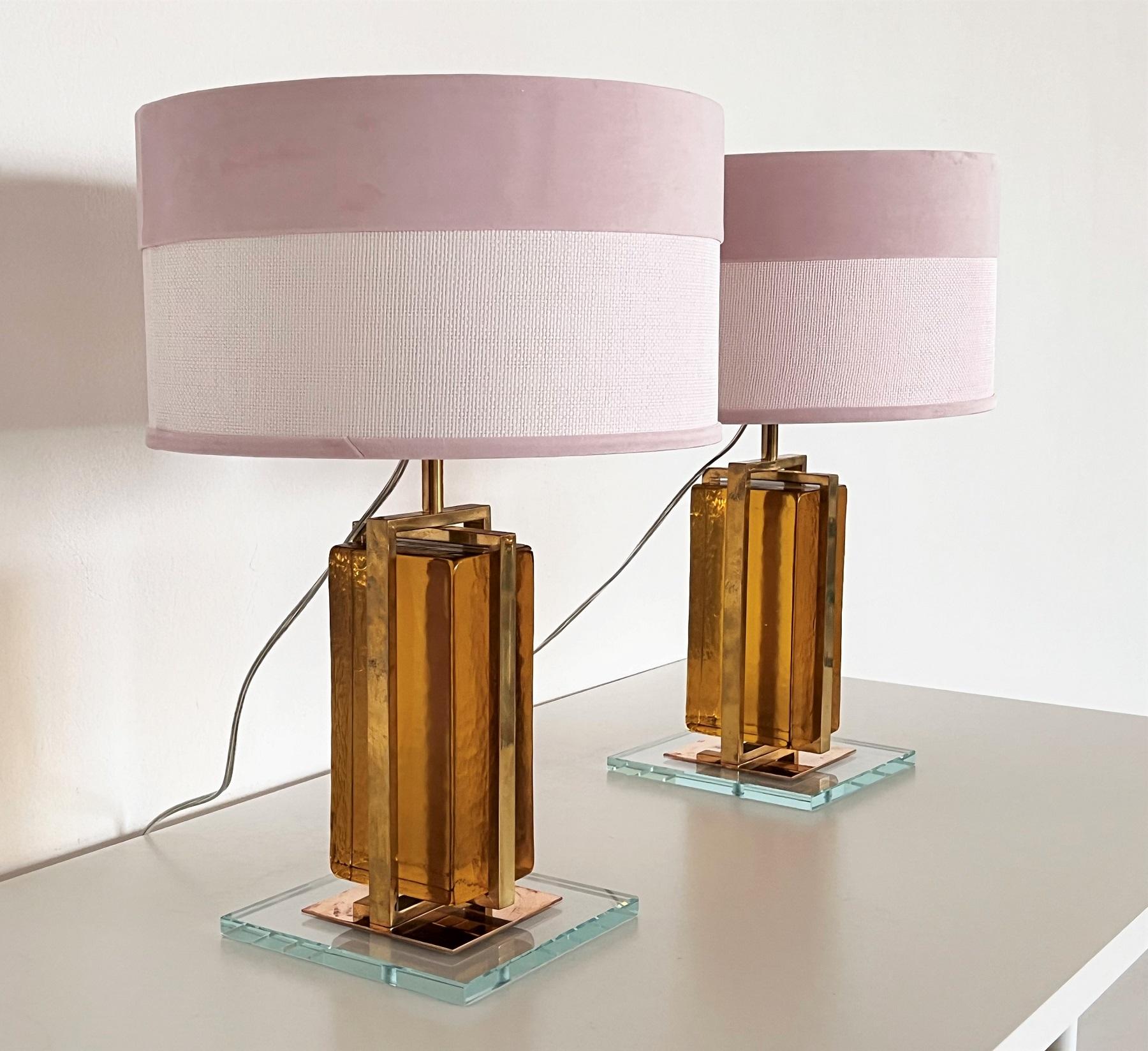 Gorgeous pair of modern Murano glass and brass block lamps. 
Manufactured circa during the 2010s. 
Perfect for todays eclectic design and fit with many styles. 
The glass blocks are closed inside the strong brass cage, and are very heavy!
Beautiful