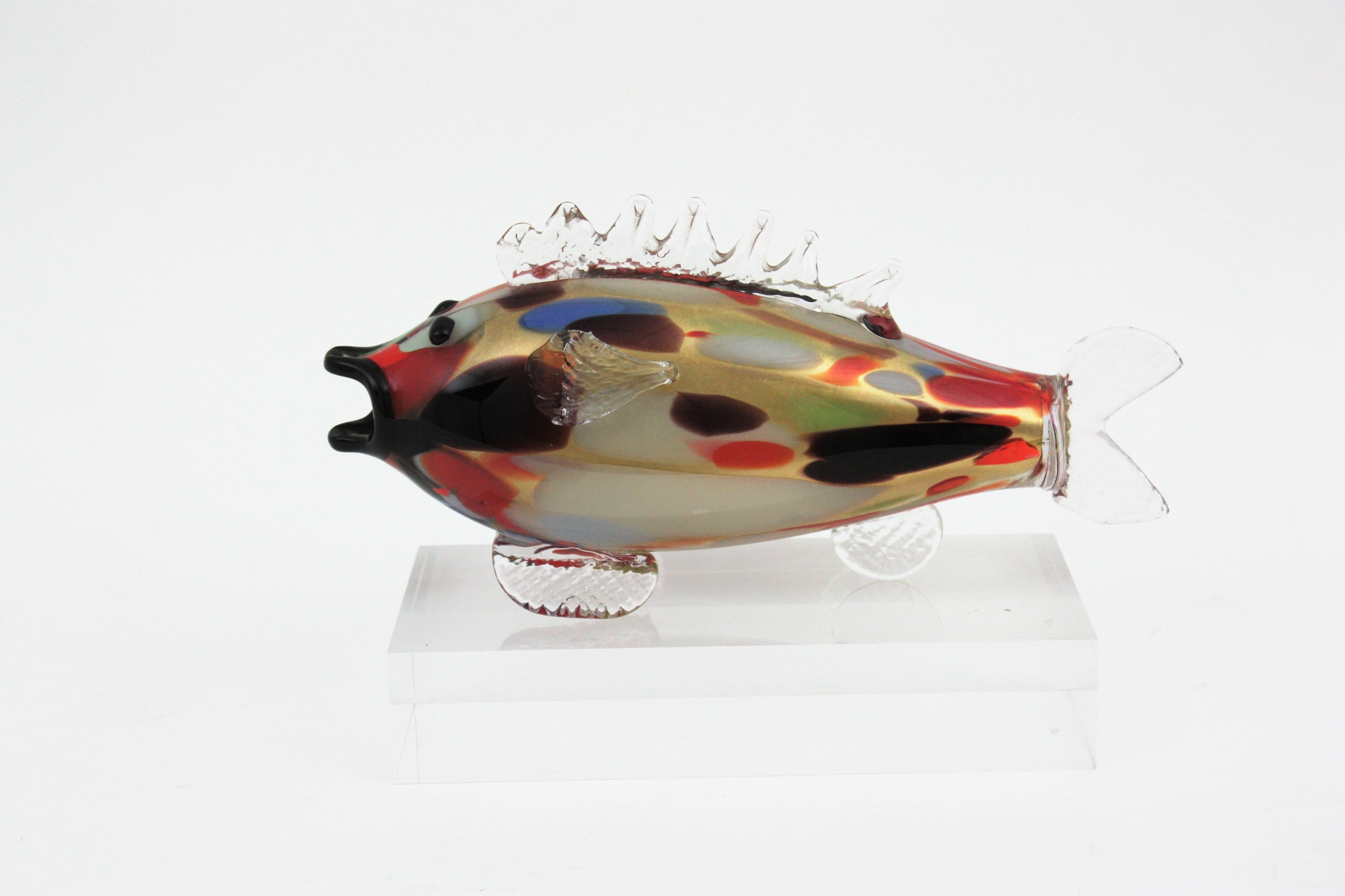 Figura di pesce in vetro di Murano soffiato a mano della metà del secolo scorso con murrine multicolori e macchie d'oro, Italia anni '50. 
Questa scultura di pesce presenta macchie multicolore in marrone, arancione, rosso, verde, blu, arancione...
