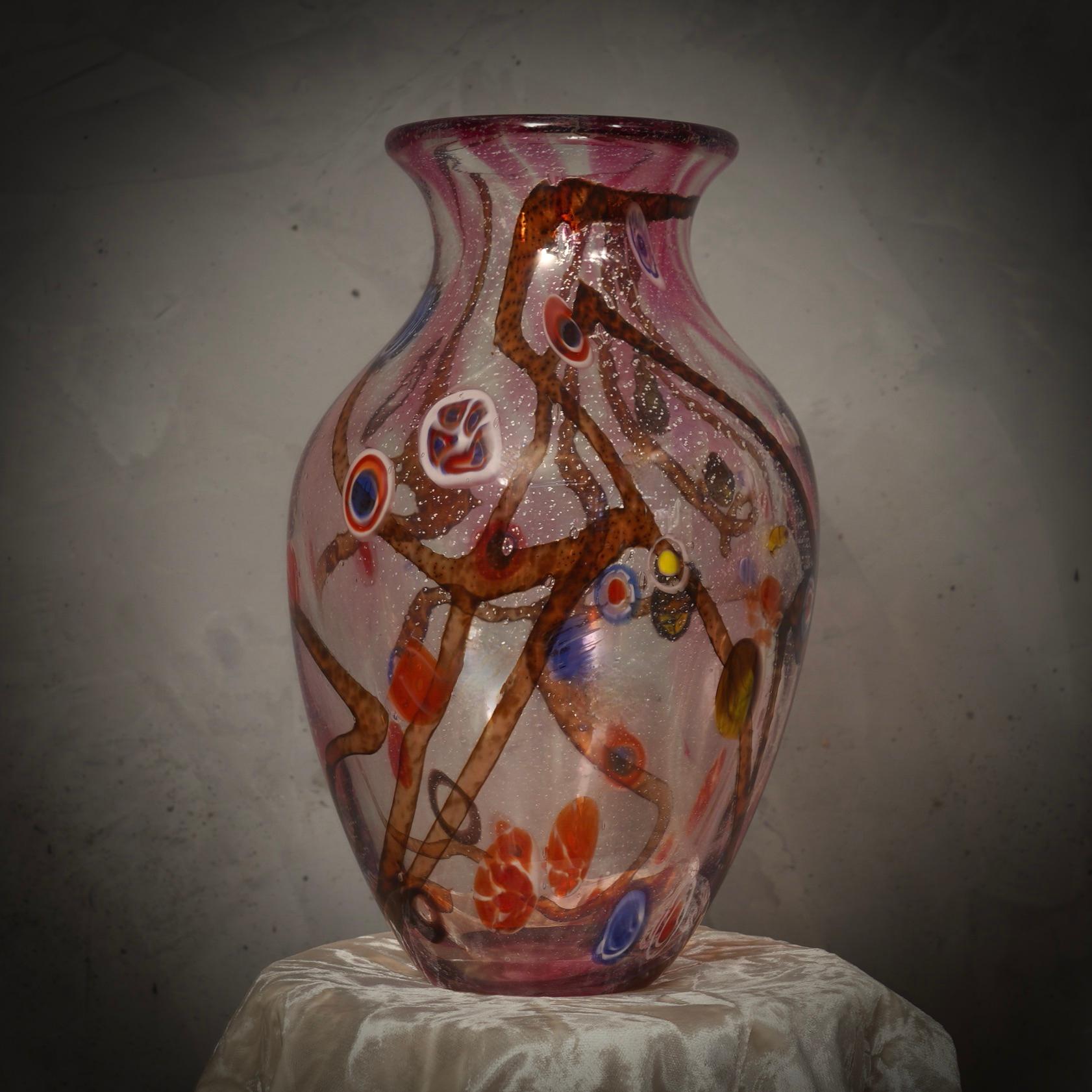 Fantastic vase from the Murano glassworks, both for its particular workmanship and for the color, in fact the vase is transparent pink in color with many murrine inside the glass.

Murano vase, with particular workmanship all around. Round section