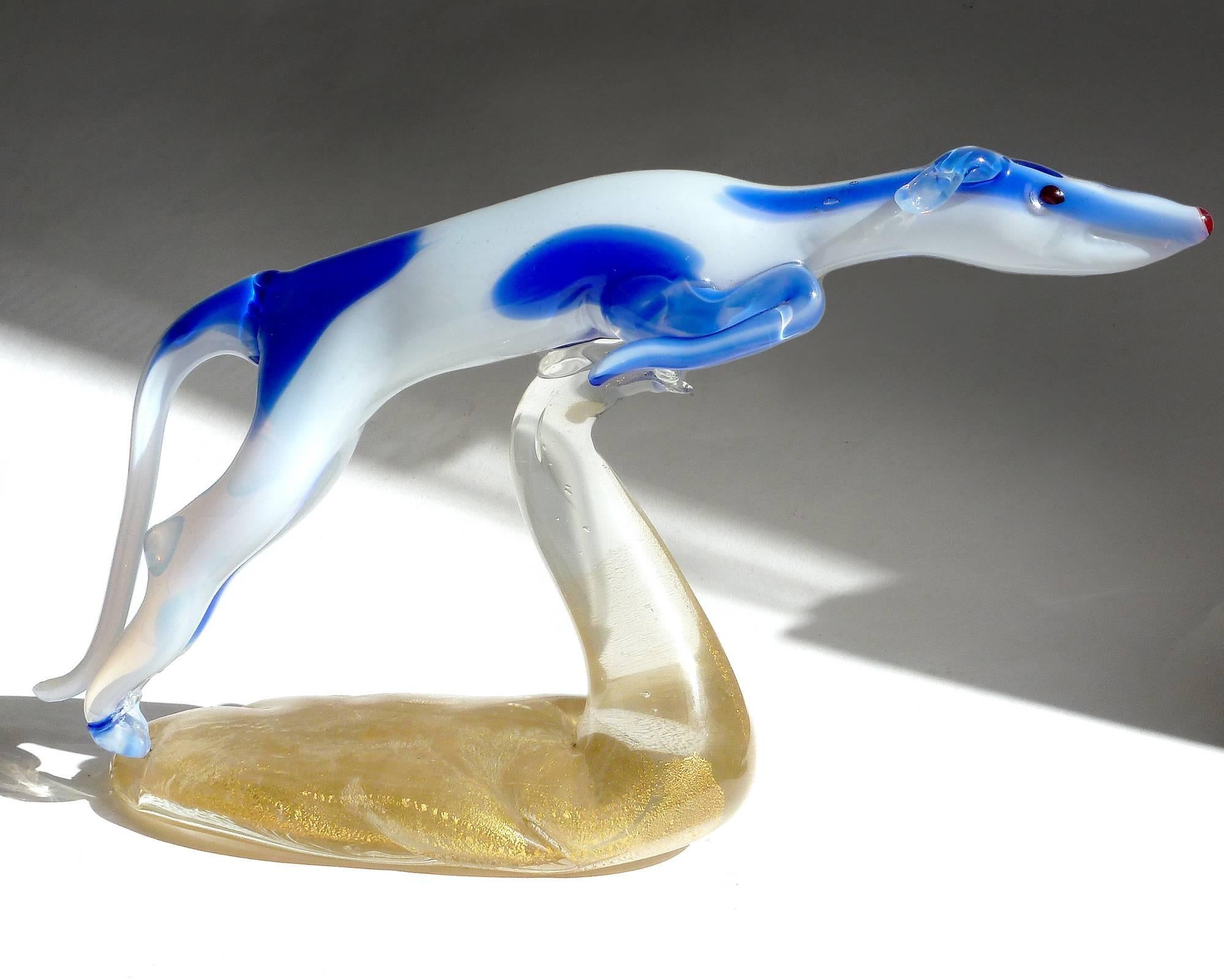 Beautiful and rare, vintage Murano hand blown opalescent white and cobalt blue spots Italian art glass leaping whippet or greyhound dog sculpture, on gold flecks base. The piece is very elegant, with an Art Deco feel, and portrays this wonderful dog