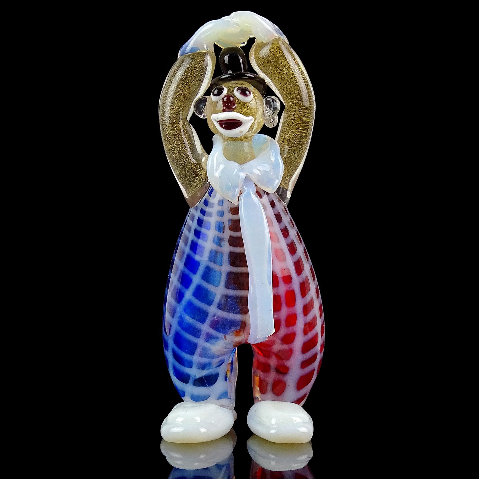Beautiful vintage Murano hand blown opalescent white, red and blue jumpsuit Italian art glass clown sculpture / figure. He has a very cute painted face and red nose. The clown also has gold flecks throughout the arms and face. He is wearing a black