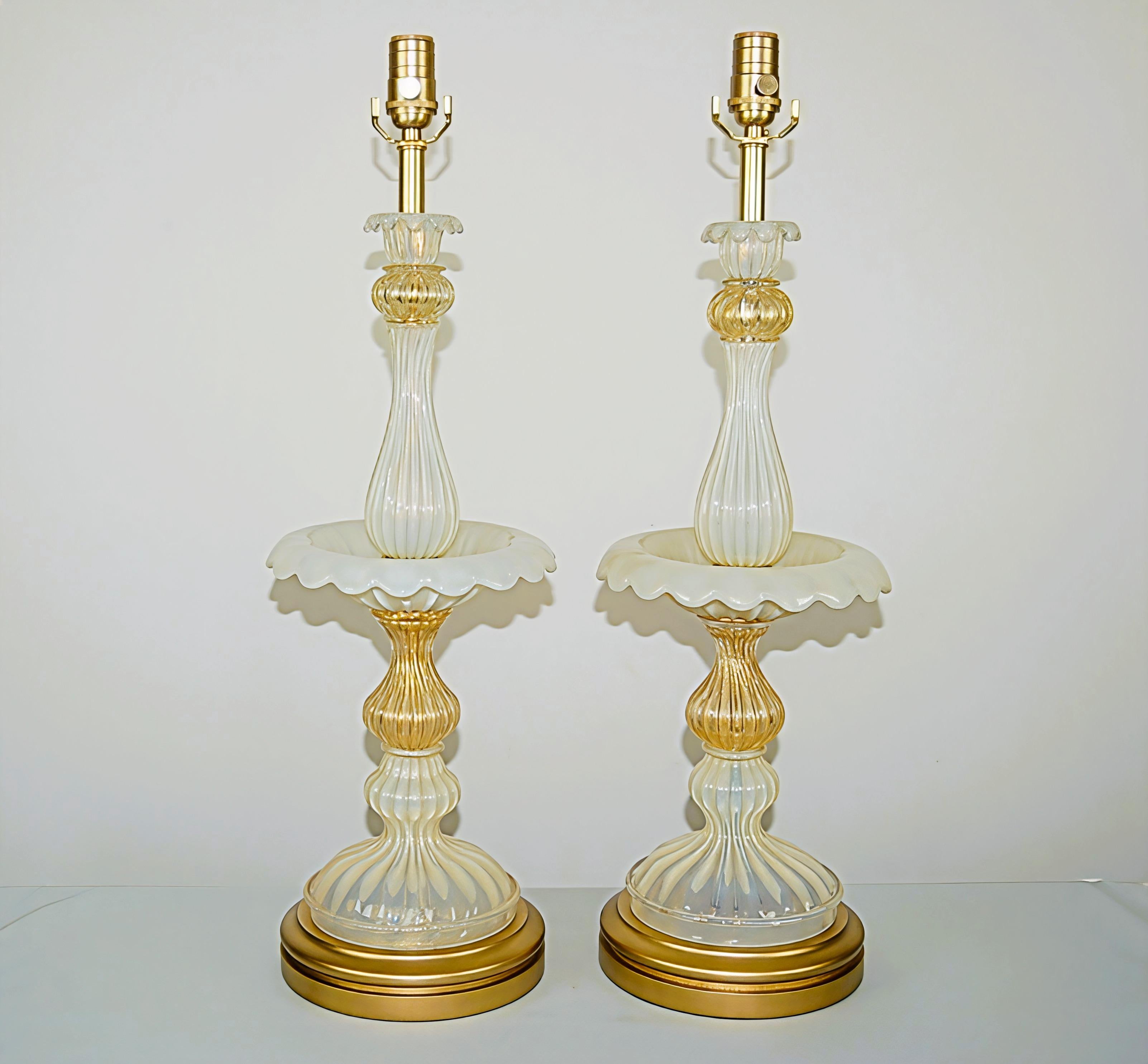 Matched pair of vintage Murano Epergne glass table lamps. Magical WHITE OPALINE and clear glass filled with GOLD – elegance so hard to come by, and in beautiful vintage condition!

They stand 27 inches from tabletop to socket top. As shown, the top