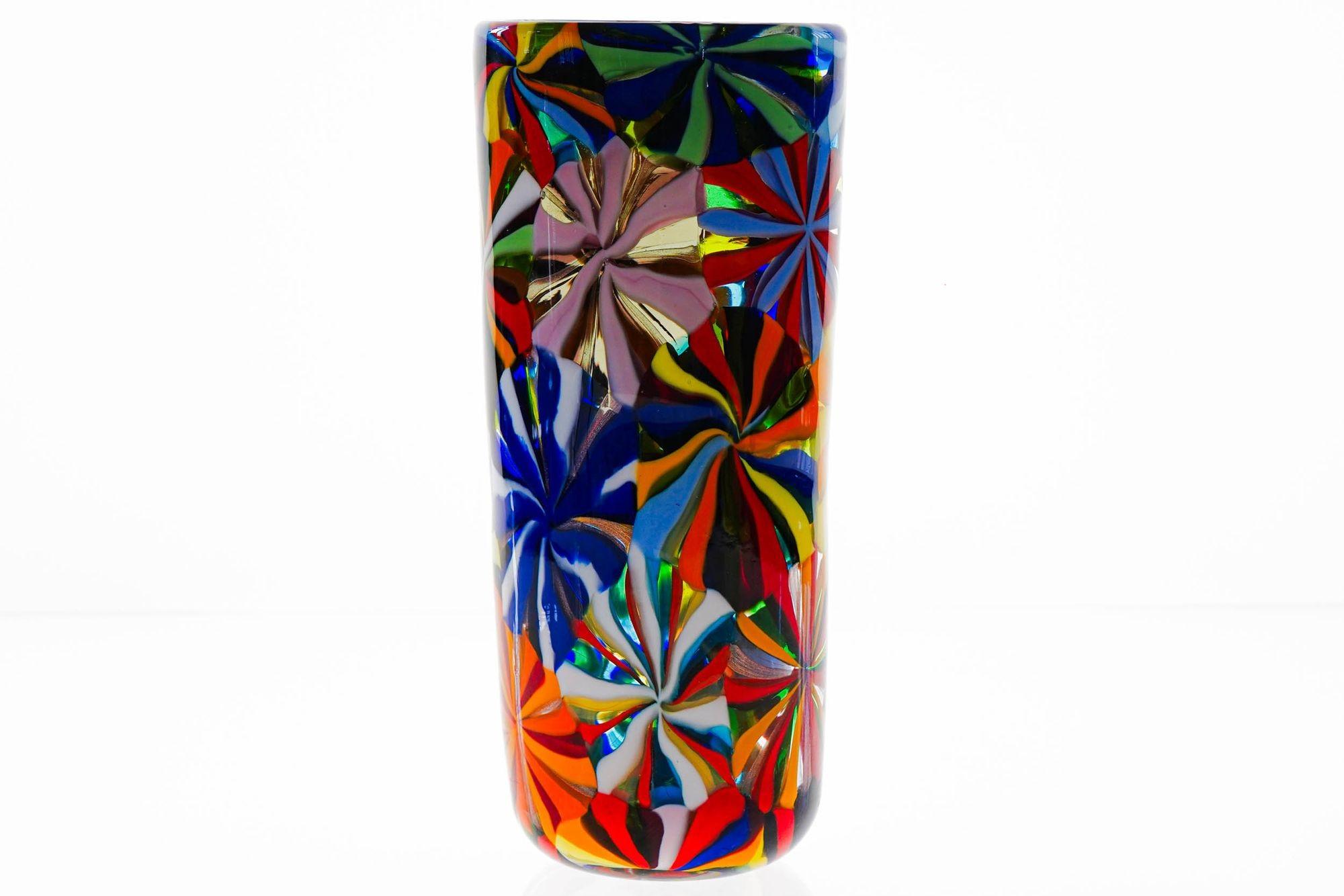 This stunning Murano mosaic vase features a perfect blend of opaque colors and a sophisticated mosaic technique.

The stellato finish is achieved by rolling canes of various colors over a small blob of heated glass. Using glass scissors, flat discs