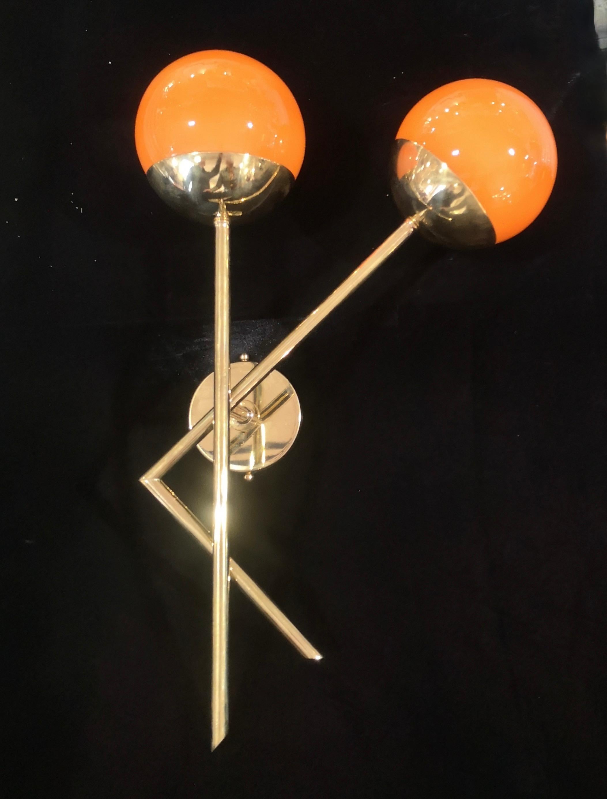 Refined and delicate design for this wall light with orange color Murano glass.

The applique are made up of a brass structure that allows the housing of a beautiful orange color Murano glass sphere. The design is very clean and simple, but at the