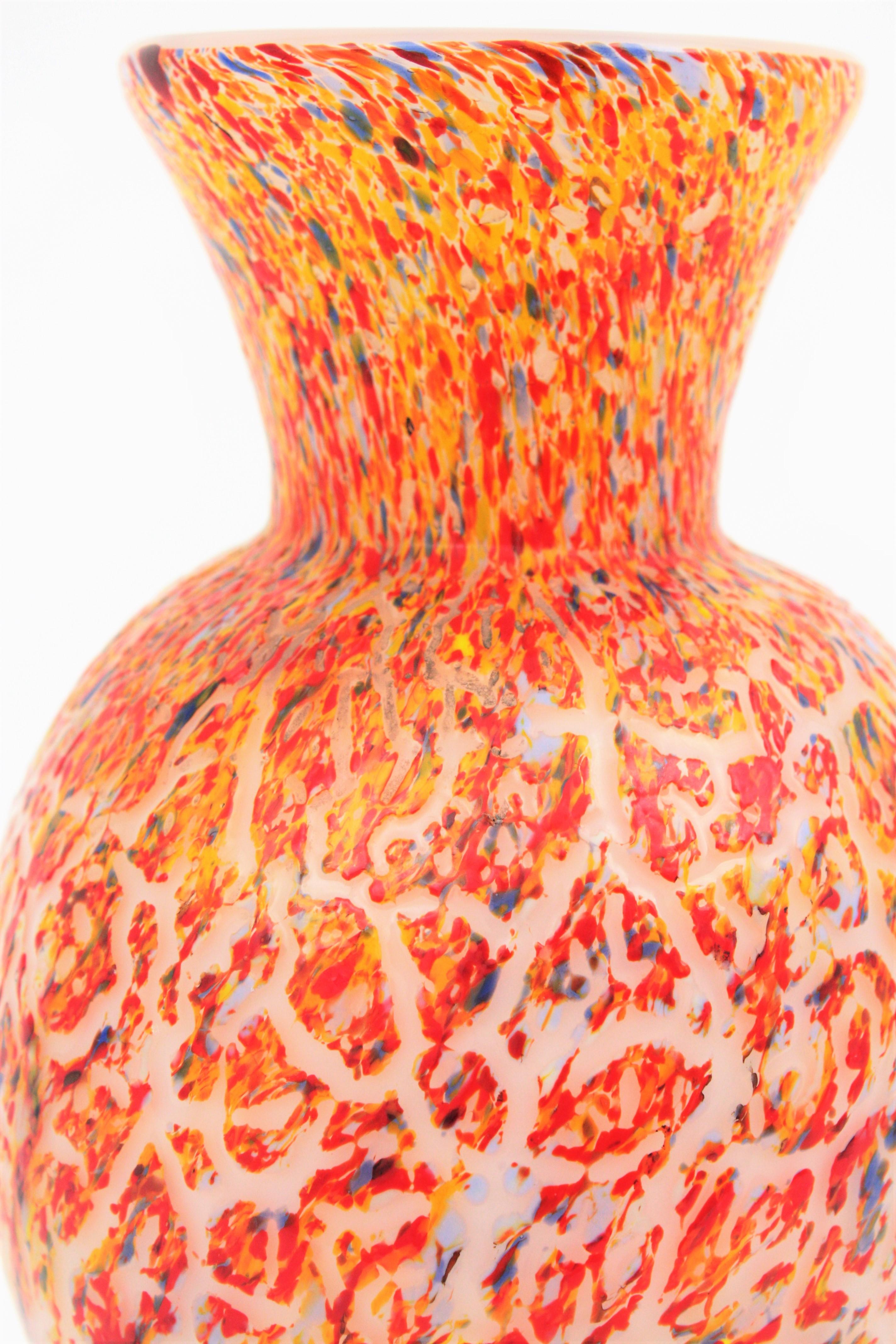 Murano Textured Italian Art multi-color confetti glass vase, Italy, 1960s
Beautiful hand blown Italian art Murano multi-color glass vase with textured surface and clear glass foot. 
Lovely to be used as decorative vase or flower vase. Perfect as a