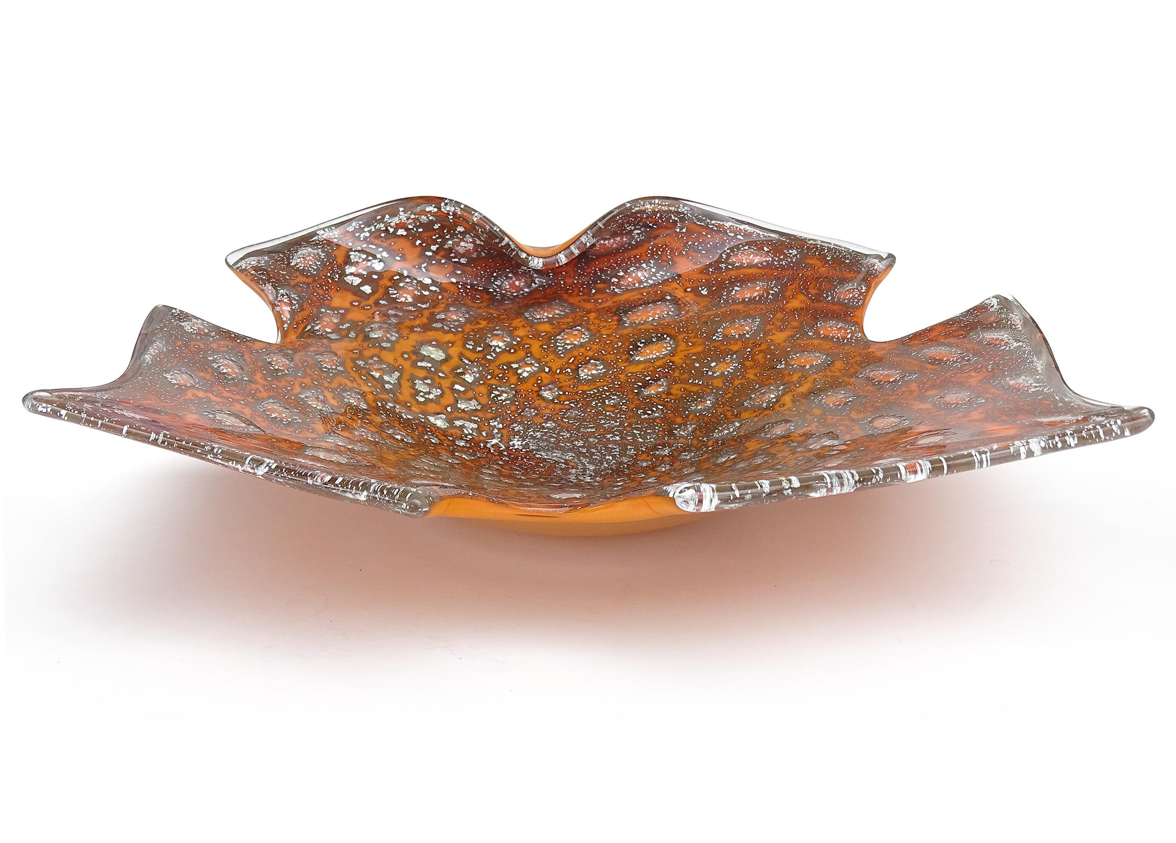 Beautiful and unusual vintage Murano hand blown orange, controlled bubbles and silver flecks Italian art glass abstract bowl. The piece has a scissor cut rim in the shape of a butterfly, with one fold on the edge. It is profusely covered in silver
