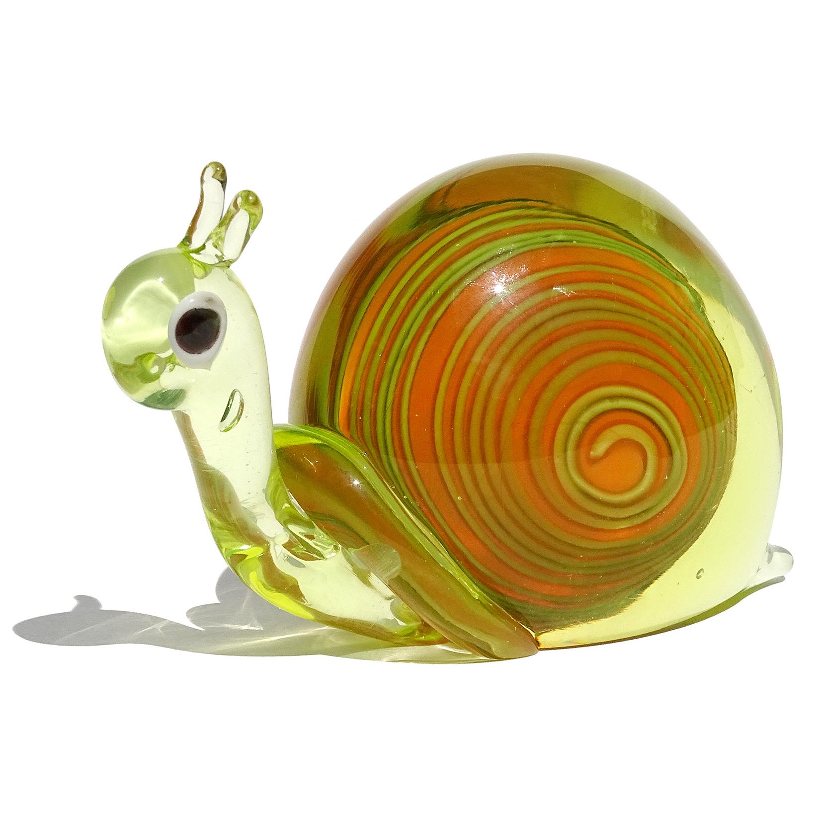 Very cute Murano hand blown Vaseline yellow green with red orange core Italian art glass snail figurine paperweight / sculpture. Documented to the Fornasa De Murano A L'Insegna Del Moreto Company, by designer Galliano Ferro. Glows under a black