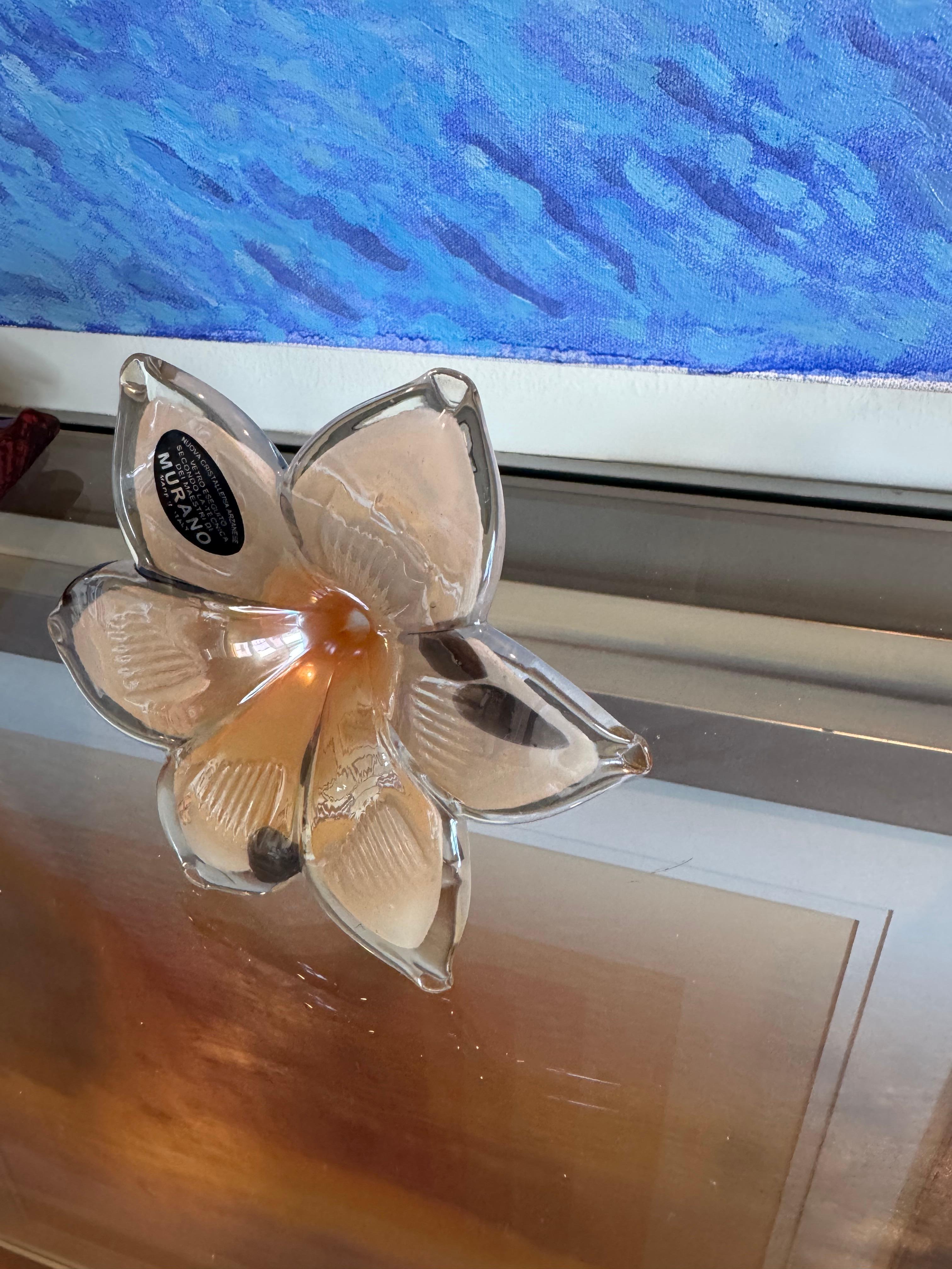 This flower is handblown.
It was crafted in Murano, Italy. 
It has a beautiful orange with black color.

Makes for a great gift.