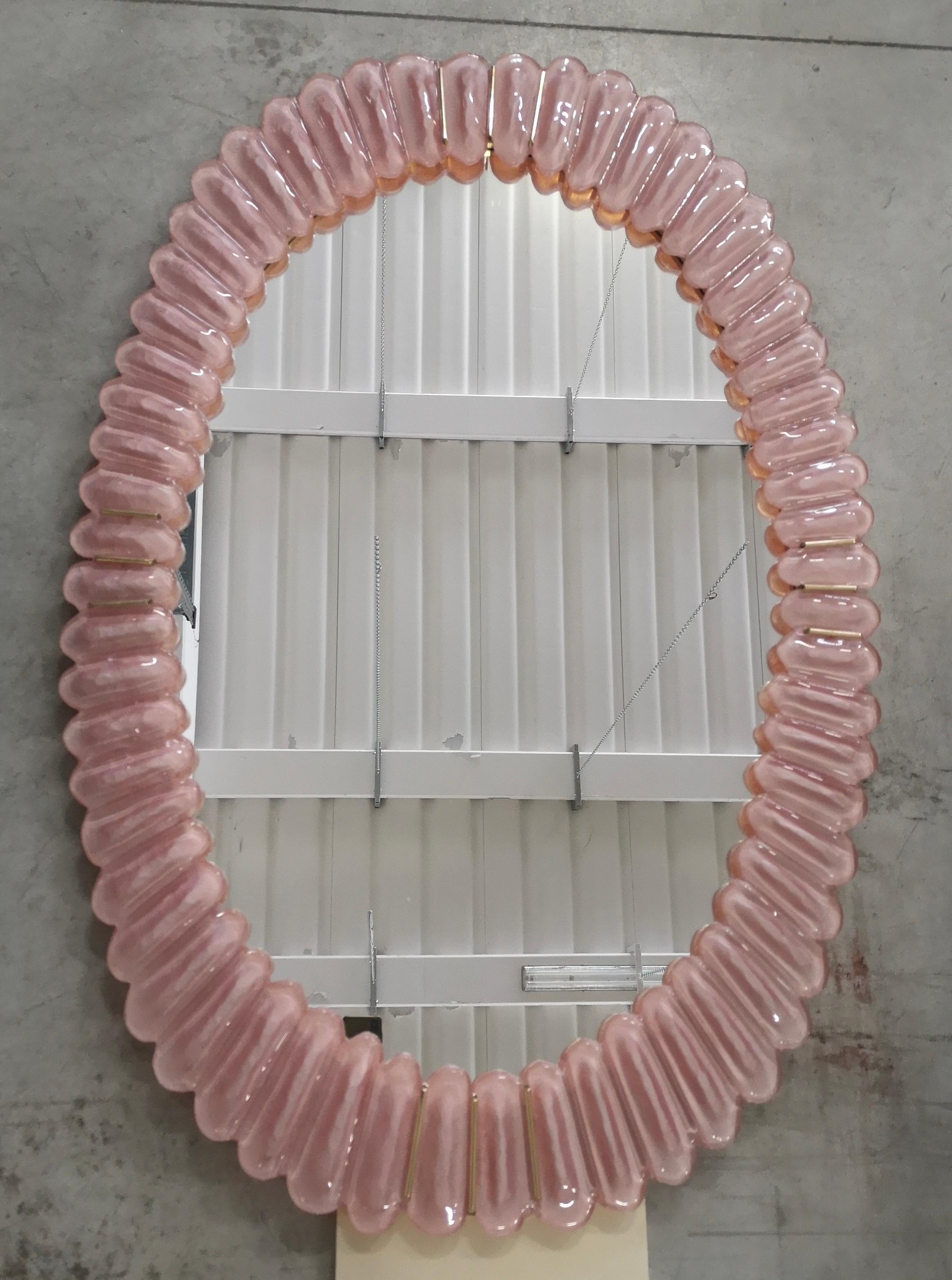 Superbe miroir en verre Murano de couleur rose flamboyant, Venise. Un miroir qui, à lui seul, meublera votre environnement domestique.

Le miroir présente une structure arrière en bois, sur laquelle quatre sections en verre rose de Murano sont