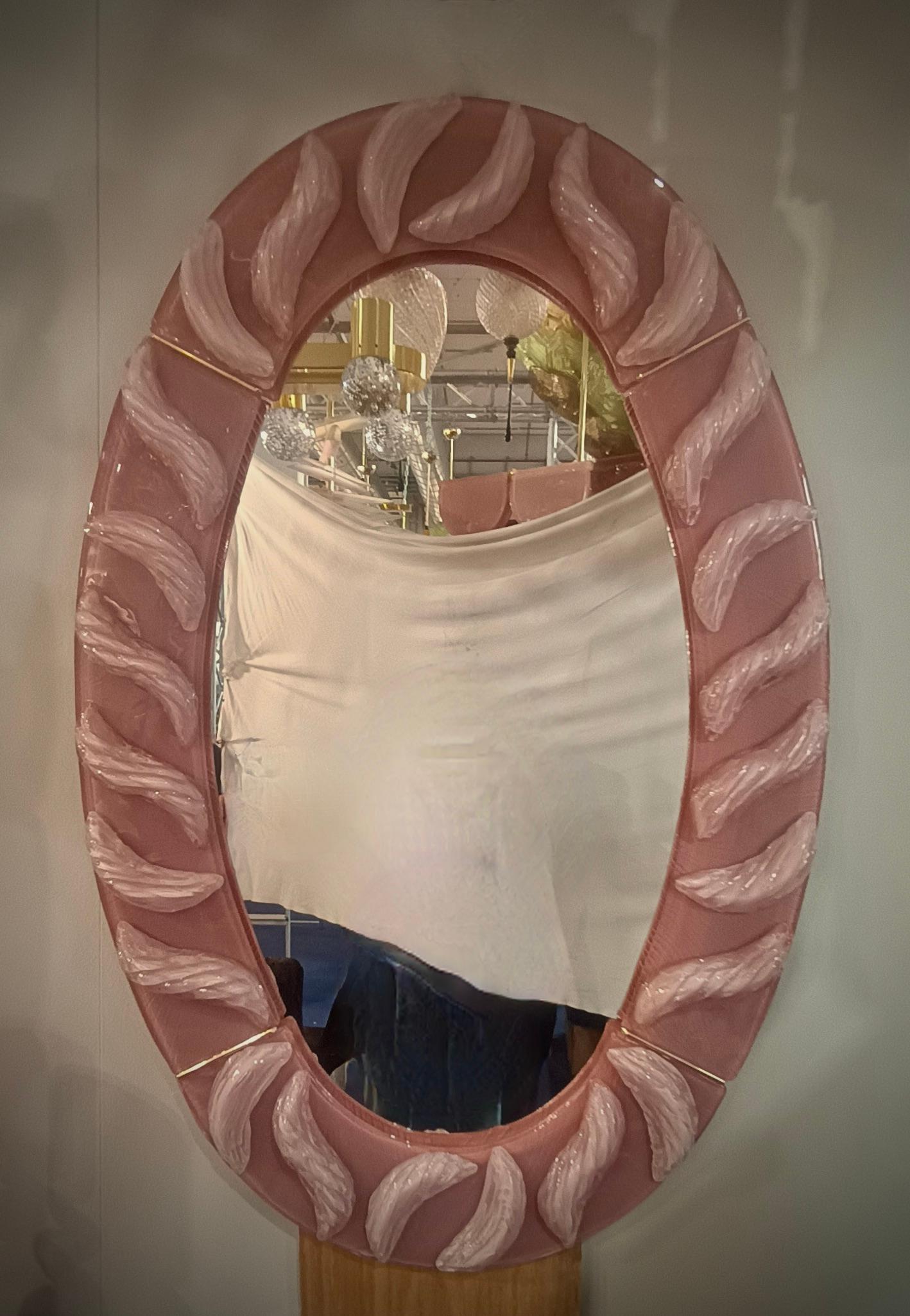 Magnifique miroir vénitien en verre de Murano rose vif. Un miroir qui, à lui seul, décorera votre intérieur.

Le miroir a une structure arrière en bois, sur laquelle quatre sections de verre rose de Murano sont montées pour former un ovale comme sur