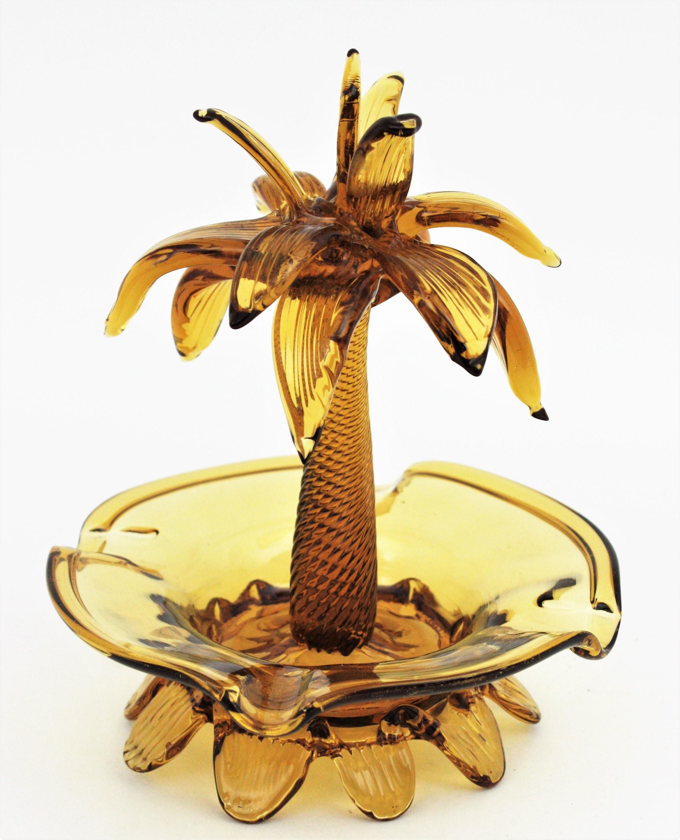 Midcentury Handblown Palm Tree ashtray / bowl, Amber Murano glass, Italy, 1960s.
This pretty beautiful palm tree ashtray has pulled glass details and swirls.
To be used as ashtray, decorative bowl, rings bowl  or to be exhibited asd a part of a