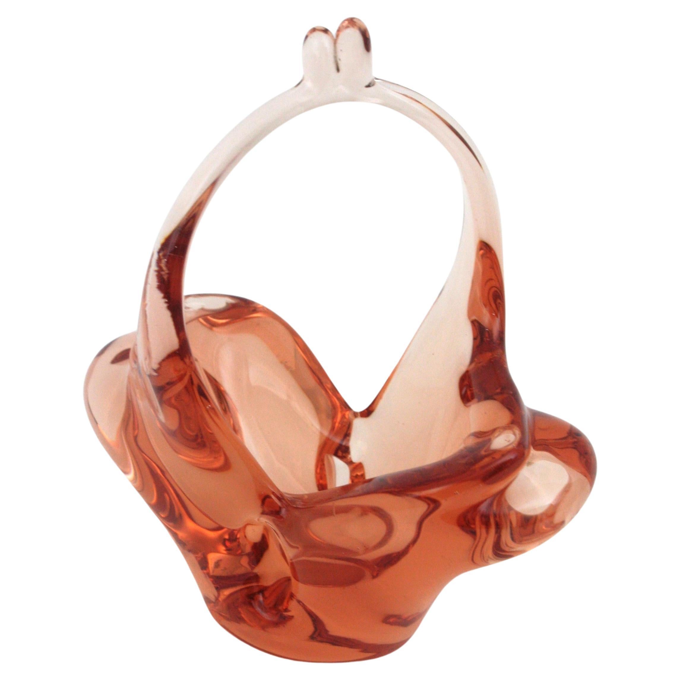 Murano Art Glass Basket Bowl. Italy, 1950s.
Lovely Murano art glass bowl in peach color clear glass. 
Finely executed in the shape of a basket.
Use it as decorative bowl, rings bowl, or candy bowl and display it alone or as a part of a Murano glass