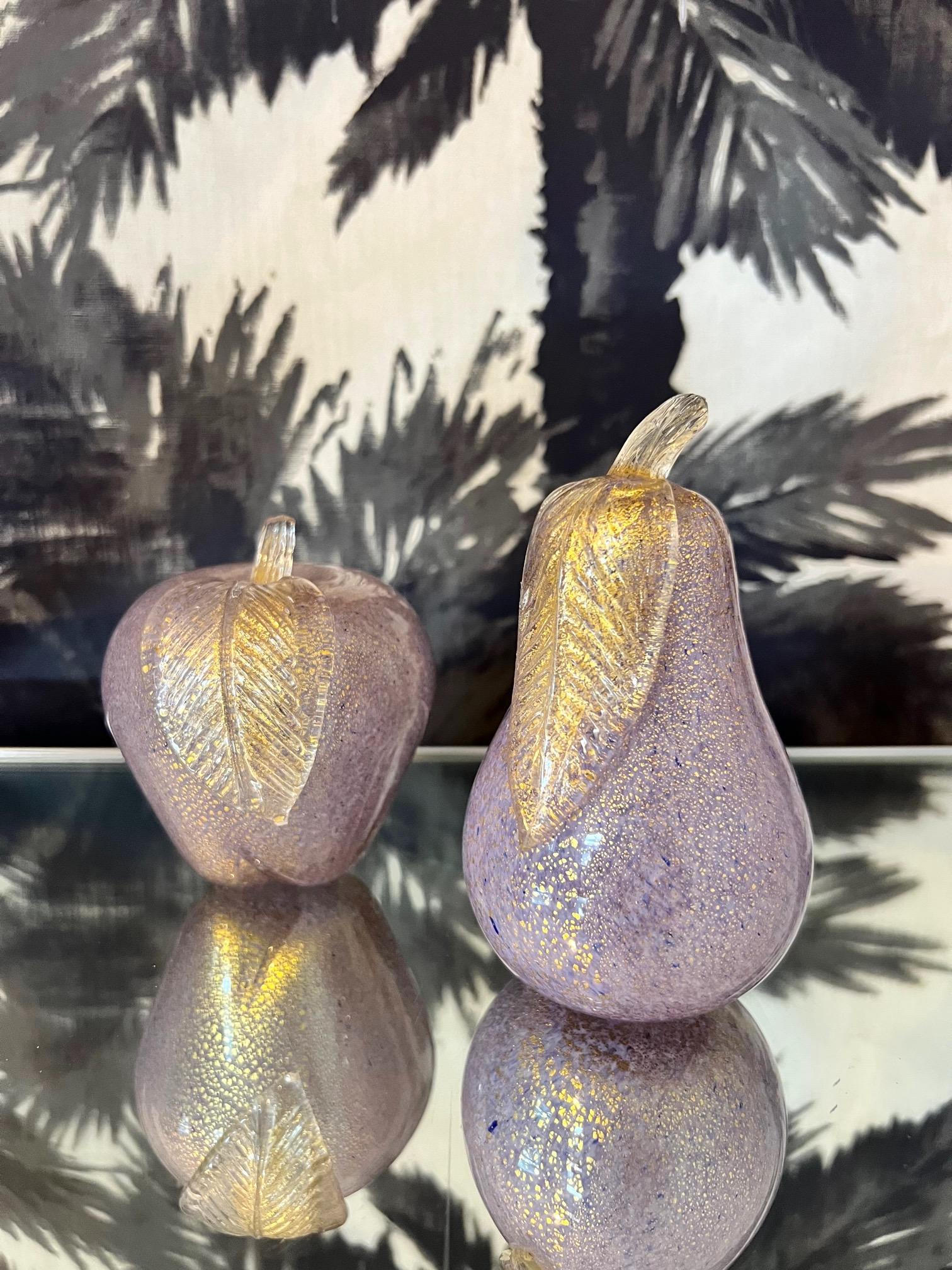 Pair of Murano glass figurative sculptures in the form of an apple and pear. Handblown glass in hues of lilac or lavender with 24-karat gold mica flecks. The figurines feature gorgeous bent glass stems with stylized fluted leafs. Chic as decorative