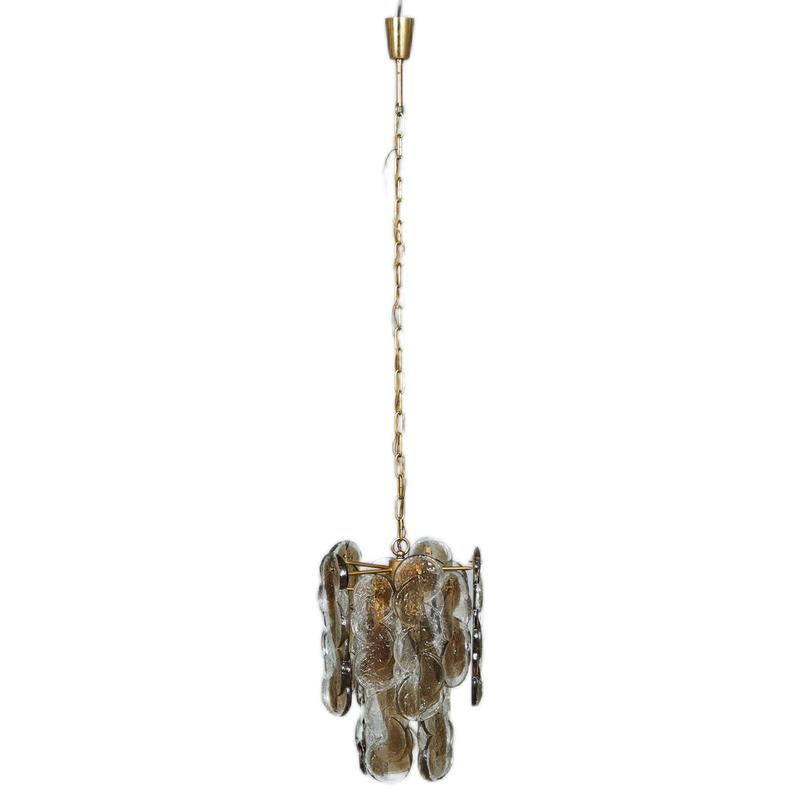 The Murano glass pendant lamp with brass structure, dating from the 1960s, is a lighting piece that captures the elegance and refinement characteristic of the era. This creation combines the craftsmanship of Murano glass with the strength and