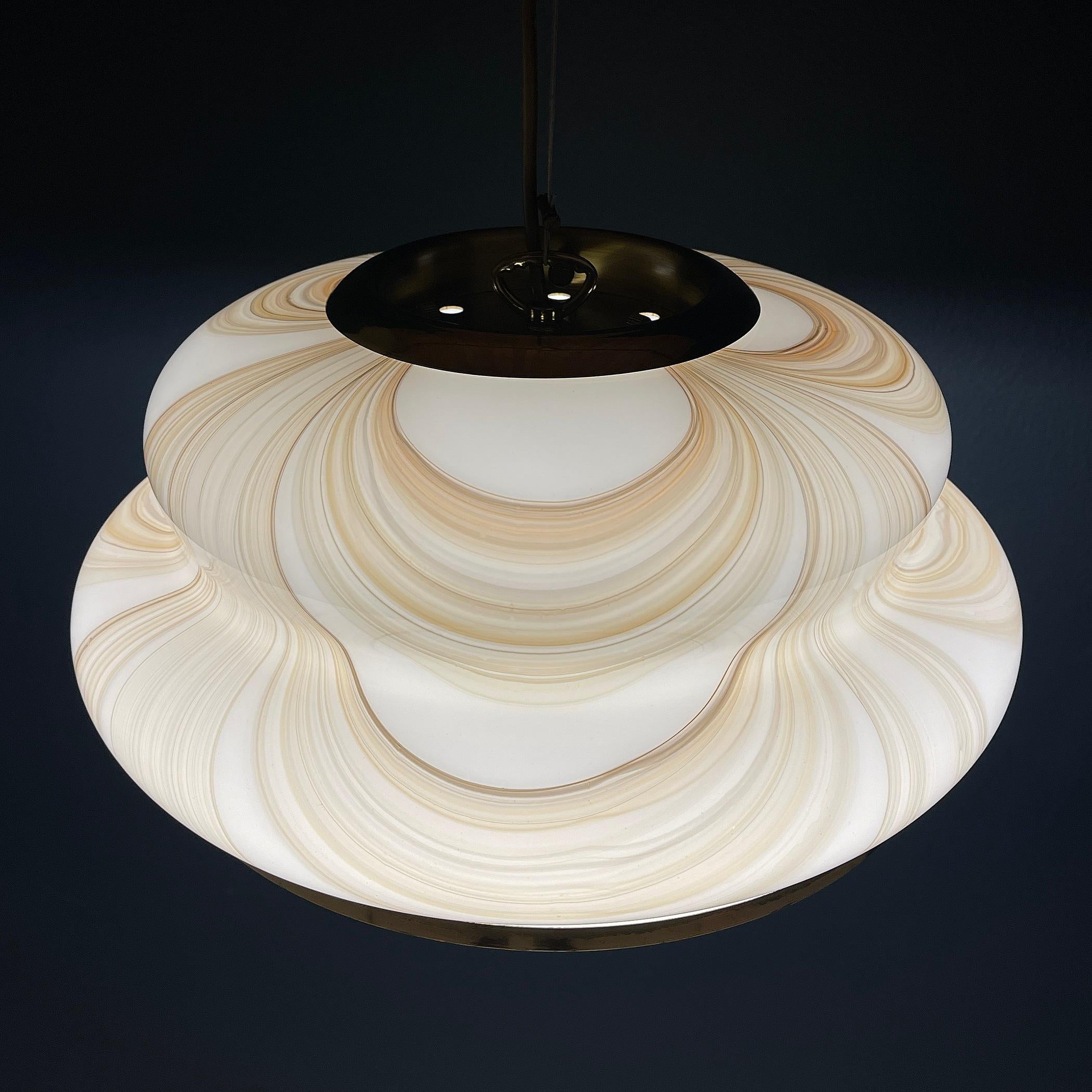 Dévoilez l'élégance de cette lampe suspendue Murano, méticuleusement fabriquée en Italie dans les années 1970. Cette pièce exquise met en valeur l'art des souffleurs de verre de Murano, où chaque détail a été délicatement soufflé à la main.