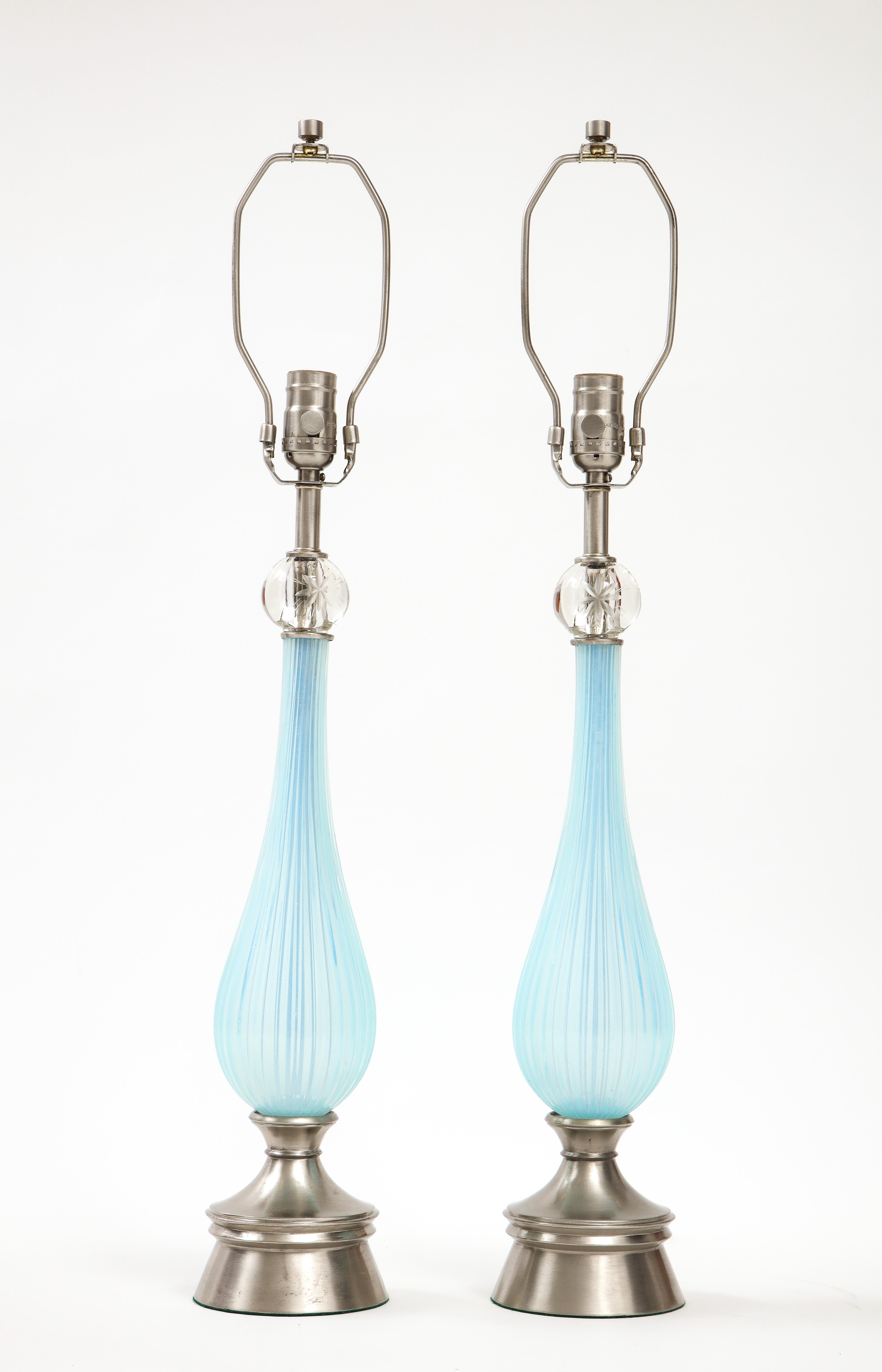 Paire de lampes en verre de Murano du milieu du siècle dernier, de couleur lilas/periwinkle. Les corps en verre présentent un design cannelé qui est surmonté d'un orbe en verre avec un élément étoilé gravé. Les lampes reposent sur une base en nickel
