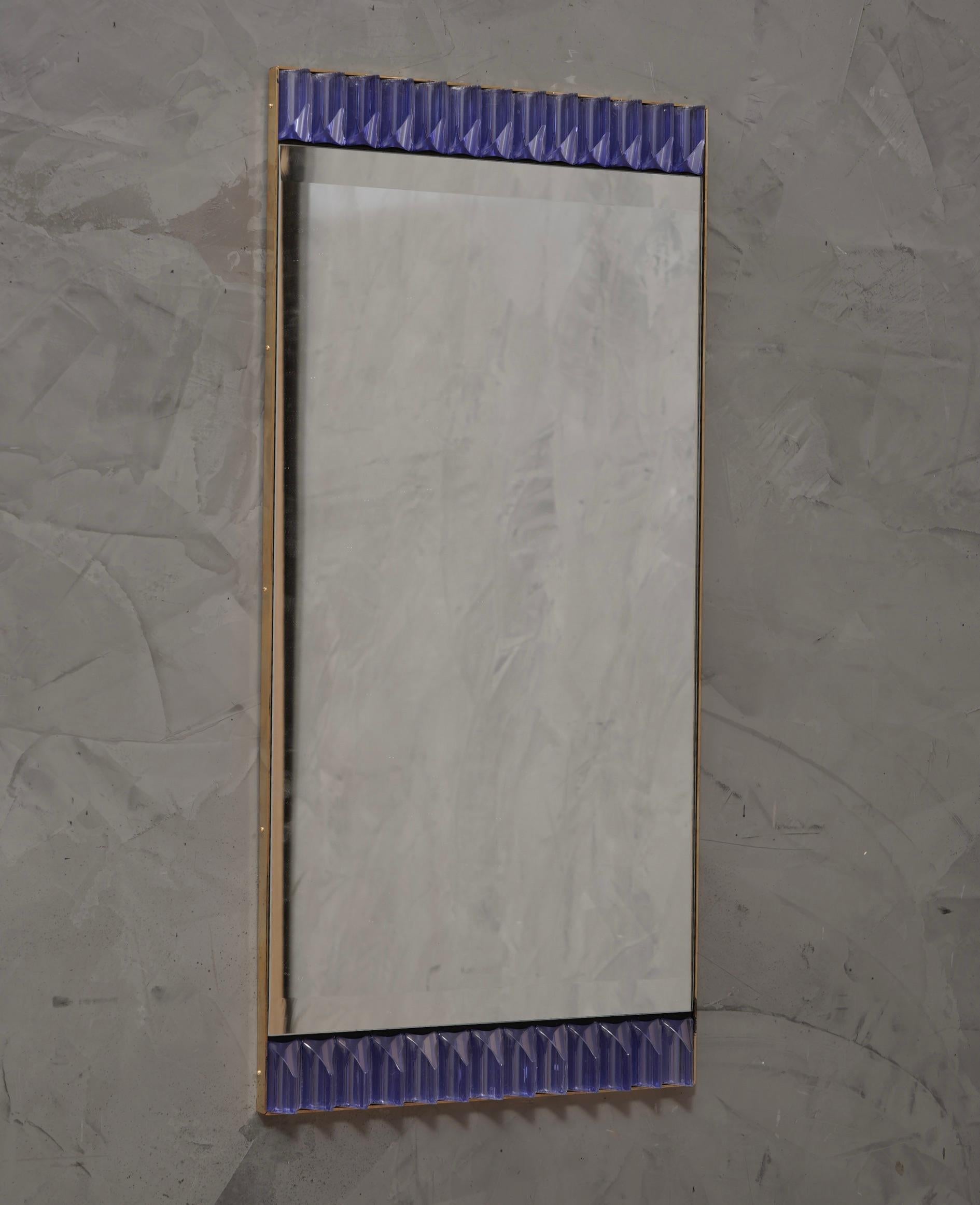 Una robusta cornice color pervinca raggiunge l'occhio di chi guarda, lasciandolo incantato; specchio da parete in vetro artistico di Murano color pervinca. Di forma splendida e di dimensioni eccellenti, lo specchio da parete è un vero e proprio