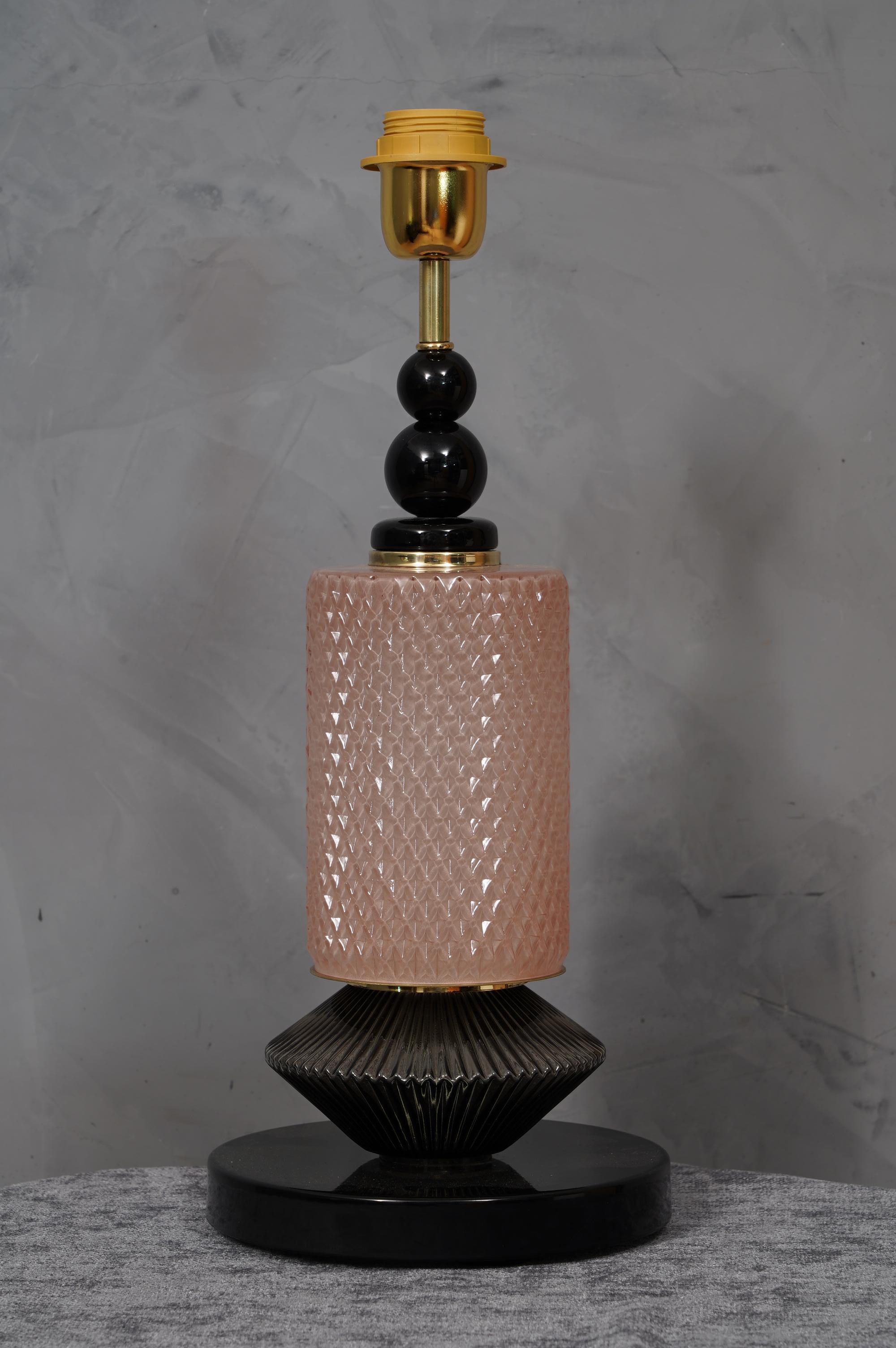 A very special and original Murano table lamps, a series of round glass arranged one on top of the other, in a pink and black color. Their shape is fascinating.

The lamp is composed of a central glass in pink Murano glass, positioned above another