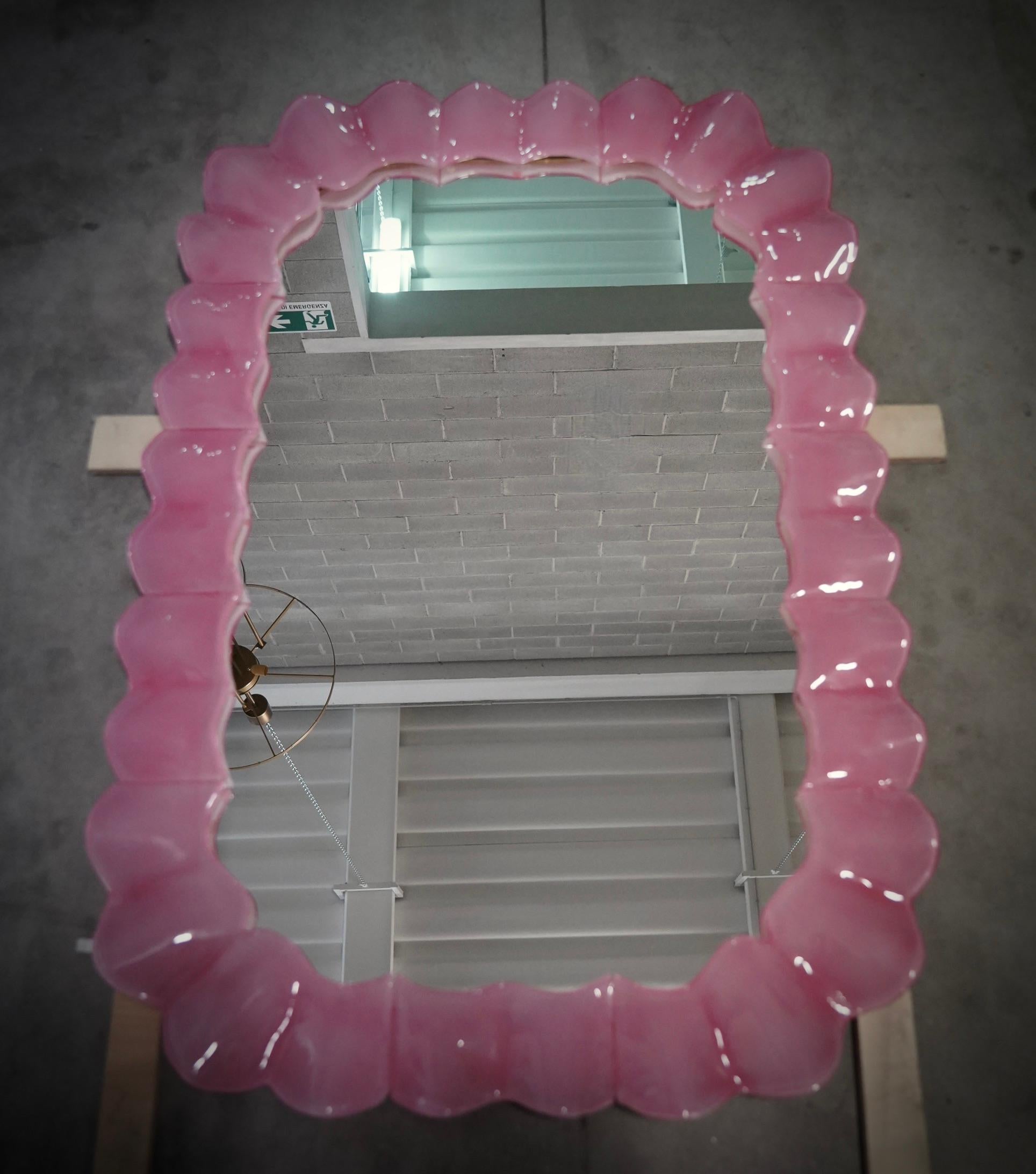 Splendid bright pink Murano glass mirror. A mirror that alone will furnish your home environment. Rich but tasteful, the mirror has a truly particular design, with a very beautiful shape of these glass sections.

The mirror has a wooden rear