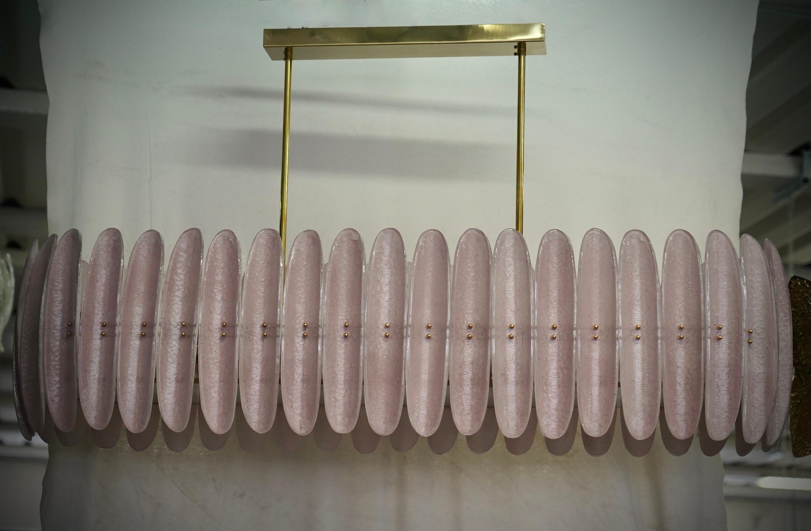 Lampadario di Murano dal design allungato con struttura in ottone e vetro singolo rosa. Il mezzo guscio di vetro è molto originale e ha un colore rosa unico.

Il lampadario ha una struttura rettangolare in ottone, sulla quale sono state applicate