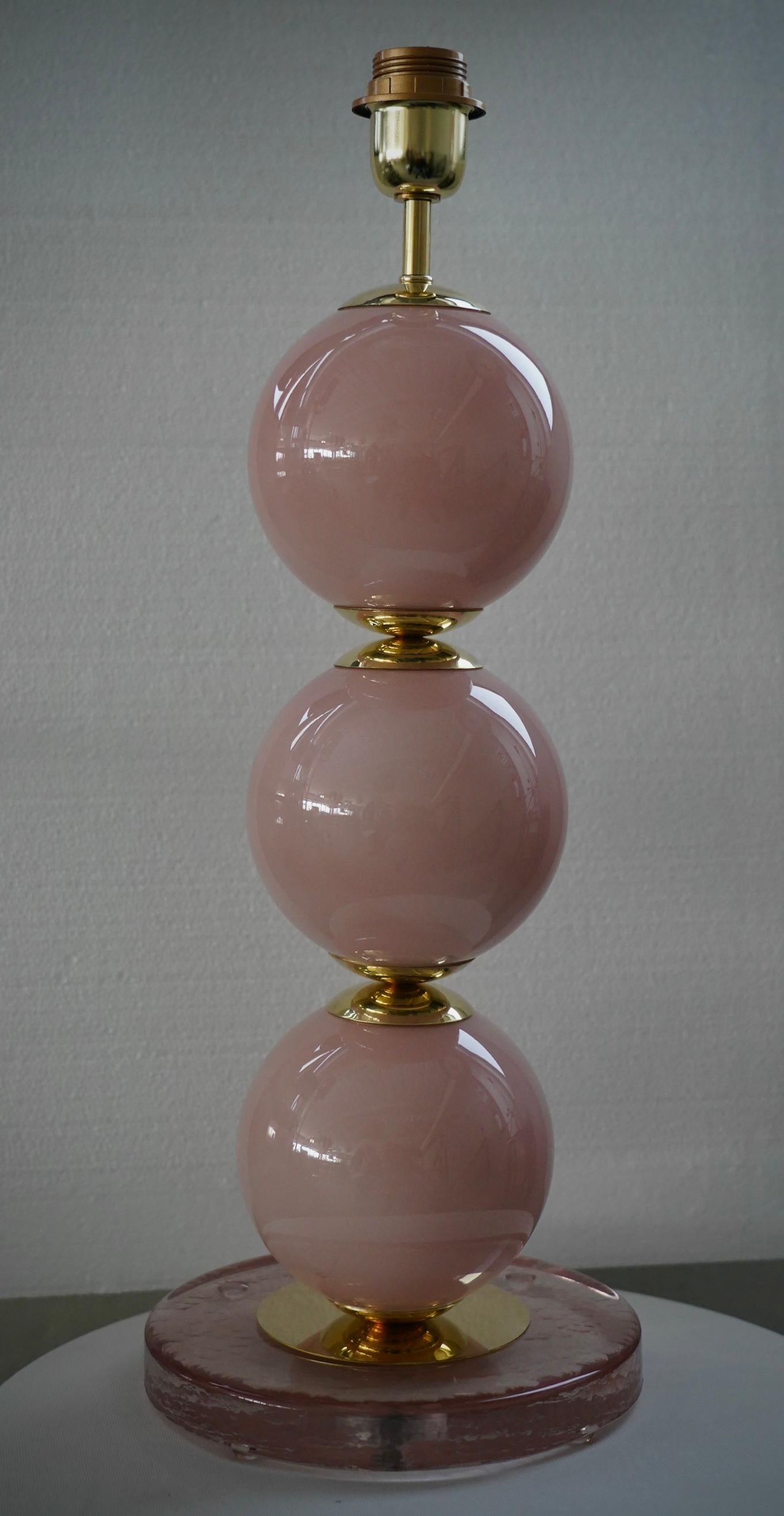 Une lampe de Murano très particulière et originale, une série de trois sphères de verre disposées les unes au-dessus des autres, en rose bonbon. Leur forme est fascinante.

La lampe est composée d'une base ronde en verre rose transparent et d'une