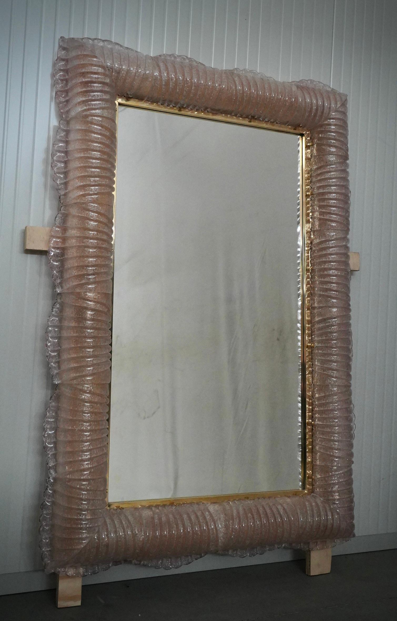 Un cadre rose robuste capte l'œil de l'observateur, le laissant enchanté : c'est un miroir mural en verre artistique rose de Murano qui s'illumine intérieurement.

La structure du miroir mural est en bois, le long du bord duquel est logé le verre