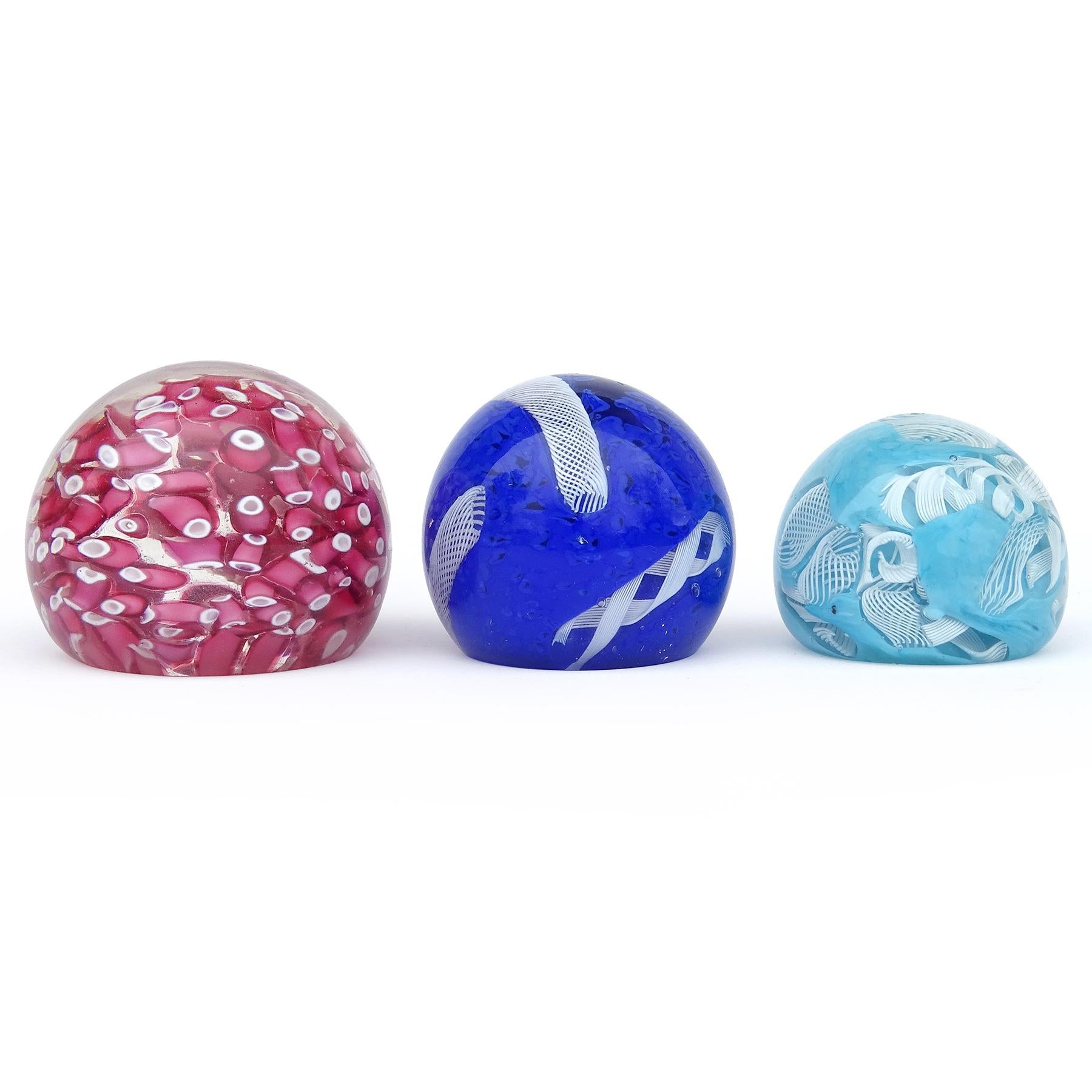 Beautiful and colorful vintage Murano hand blown pink, blue, and white Italian art glass paperweights set. The larger of the 3, in pink is documented to designer Alfredo Barbini, and the other blue paperweights have been attributed to both Barbini