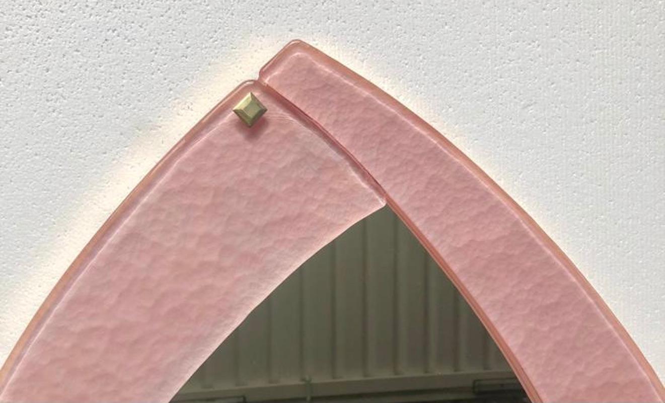 A strong pink frame reach the eye of the beholder leaving him entranced; a Murano pink art glass wall mirror.

The mirror has an oval / rhomboid shape, it is made up of four glass plates positioned on the four sides of the rhombus; the mirror is