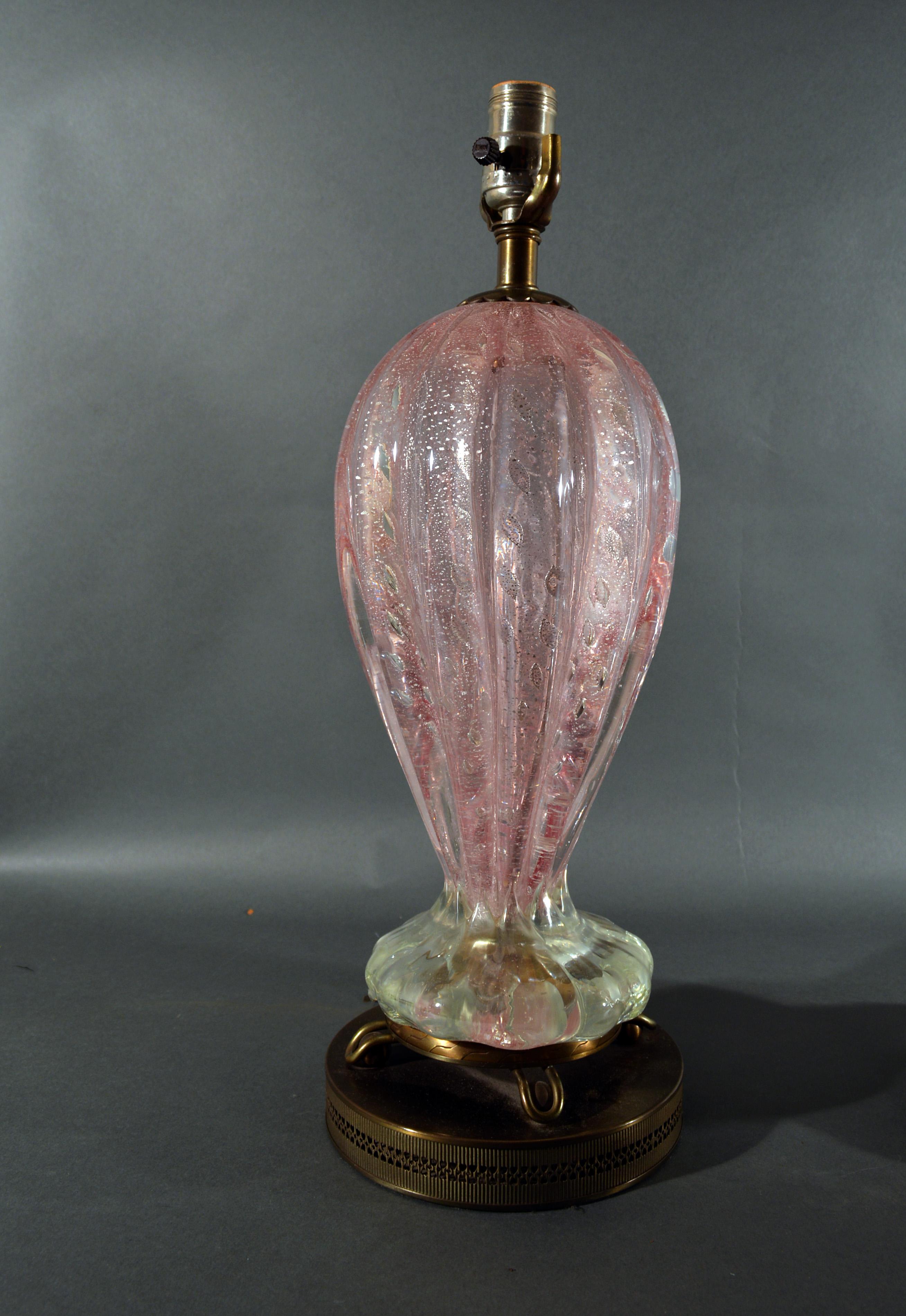 Murano pink glass with bullicante and silver flakes table lamps,
A pair,
Possibly Barovier & Toso,
1950s.


The lamps in pink with silver flakes and air bubbles in a style known as Bullicante are raised on three curled gilt feet which stand on